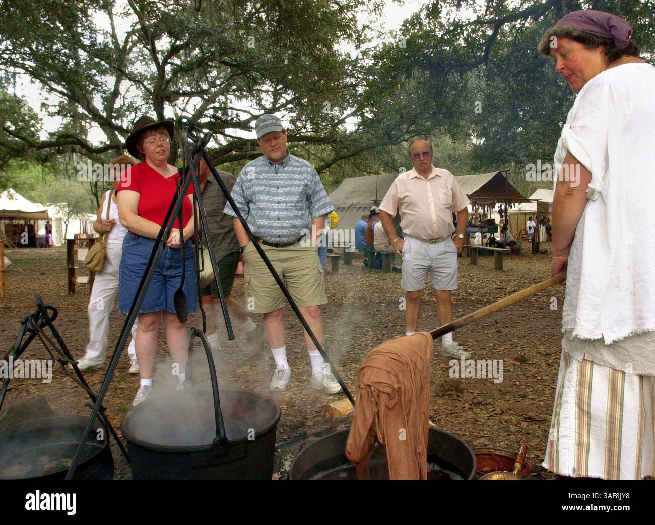 PT 134845 - - LIEFERUNG AN: Pasco - - 2/2/2002 - - Dade City BILDUNTERSCHRIFT: Am Mountain man Rendezvous am Samstag, 2.2002, im Withlacoochee River Park in Dade City, Vicki Webeck (CQ) (rechts) von ehrlichen Stichen in Zephyrhills demonstriert frühe Stofffärbung zu Mary White (CQ) (links) von Haddonfield NJ und will White (CQ) (in blau & Hut) von Credit Oderk Times (Bild): St. Petersburg/Oderk) (Bild: ZUMAPRESS.com). Stockfoto