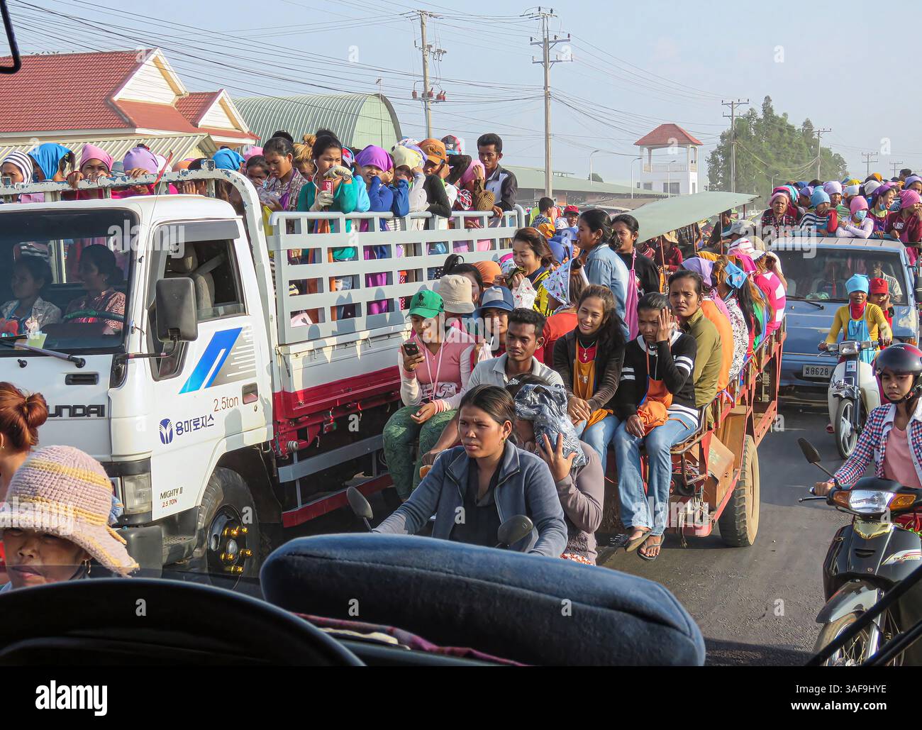 Provinz Kampong Speu, Kambodscha. April 2025. Bekleidungsarbeiter verlassen Fabriken in LKW – ein typischerweise chaotisches Ende des Arbeitstages, das heute von wachsender Besorgnis geprägt ist. Der kambodschanische Textilsektor, in dem rund 1 Million Menschen beschäftigt sind, wird von US-Zöllen von bis zu 49 % getroffen, die vom Handelsministerium als „nicht angemessen“ eingestuft werden. Ein Beamter des Weißen Hauses beschuldigte das Königreich, als Front zu agieren, und erklärte: „China hat Kambodscha zum wichtigsten Umschlagdrehkreuz gemacht, den das kommunistische China benutzt, um unsere Zölle zu umgehen.“ Die Hälfte der Fabriken des Landes ist in chinesischem Besitz...Kevin Izorce/Alamy Live News Stockfoto