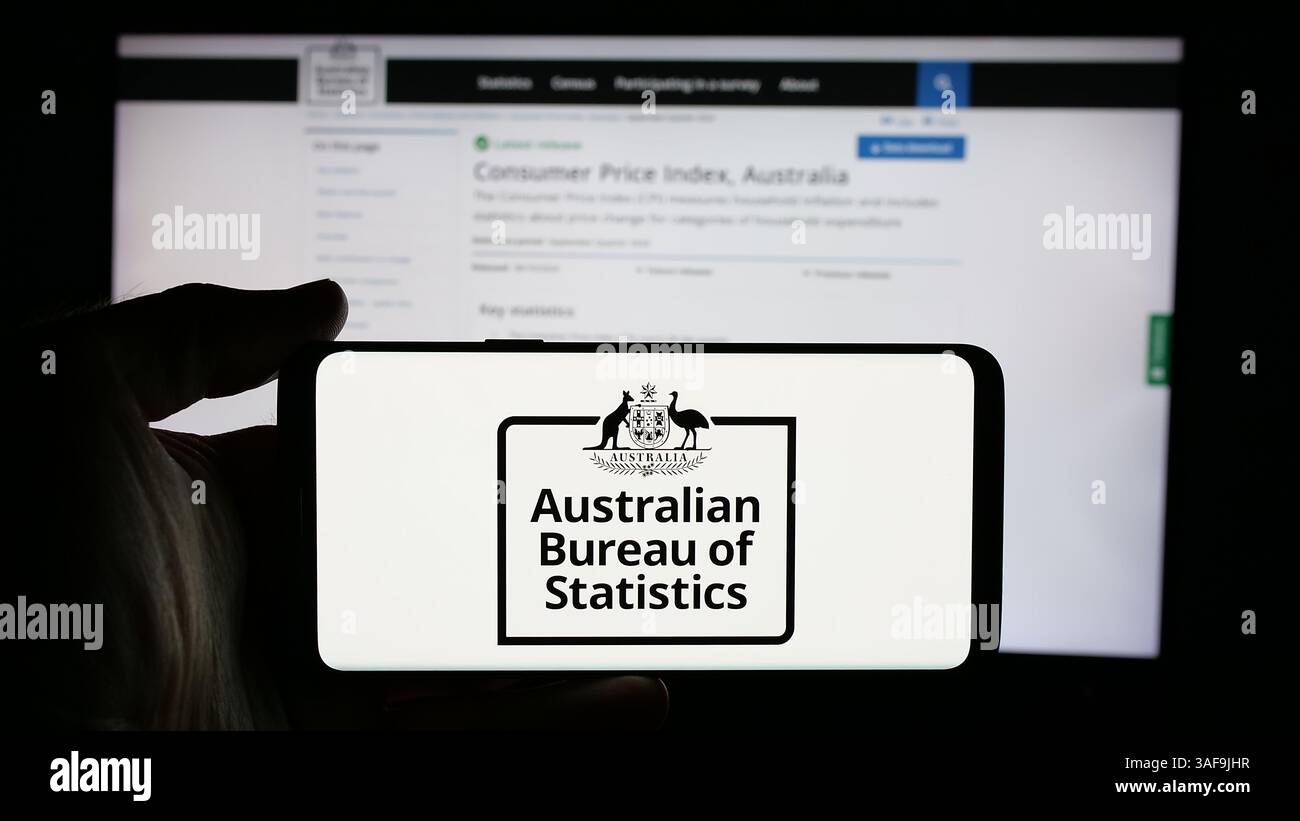 Stuttgart, Deutschland - 21.11.2024: Person, die ein Mobiltelefon mit dem Logo der Agentur Australian Bureau of Statistics (ABS) auf dem Bildschirm vor der Webseite hält. Stockfoto