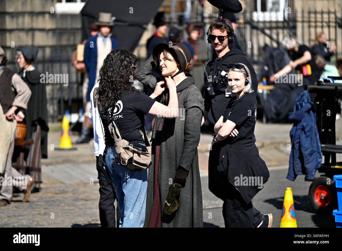 Edinburgh, Schottland, Großbritannien. April 2025. Charlie Murphy wird bei der Kostümanpassung unterstützt. Dreharbeiten in einem abgeschlossenen Charlotte Square, einem Drama aus der Zeit „Miss Pirie and Miss Woods“, eine wahre Geschichte aus dem Jahr 1810 mit Flora Nicholson und Charlie Murphy in den Hauptrollen. Quelle: Craig Brown/Alamy Live News Stockfoto