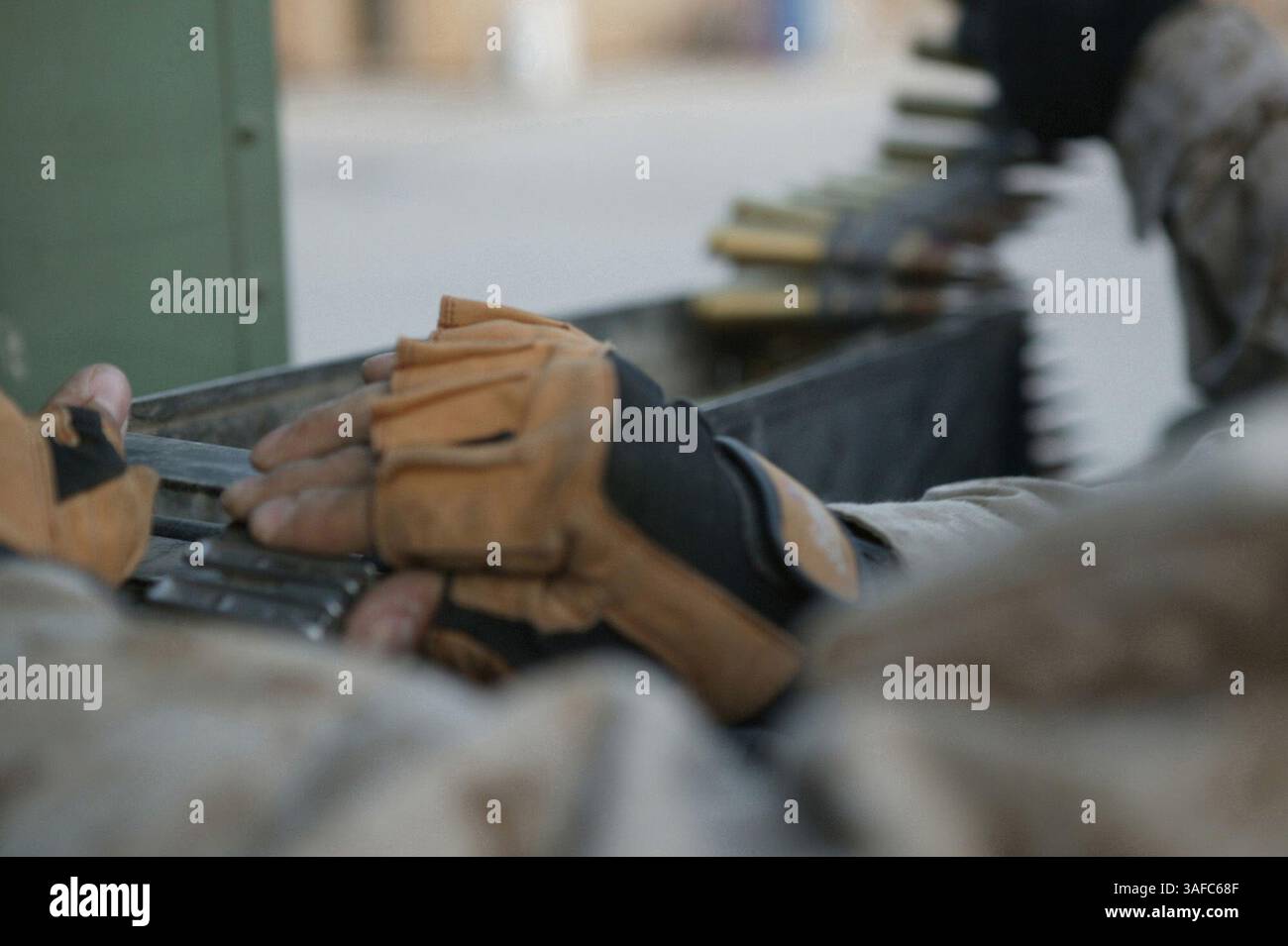 März 2004; Al Asad, Irak; Ein Marine der Alpha Kompanie, 3. Low Altitude Air Defense Battalion, entfernt die Munition aus einem Maschinengewehr des Kalibers .50 bei einem Nachtbeobachtungsflug am 25. März. Das Maschinengewehr des Kalibers .50 wird verwendet, um ein Ziel zu „markieren“, bevor die Flugabwehrrakete vom Avenger-Fahrzeug abgefeuert wird. Marines der 3. LAAD und der Lima Company, 3. Bataillon, 24. Marine Regiment, sind dem 3. Marine Aircraft Wing als Sicherheitsbataillon angegliedert und patrouillieren im 3. MAW-Zuständigkeitsbereich. (Kreditbild: ZUMA Press/ZUMAPRESS.com) Stockfoto