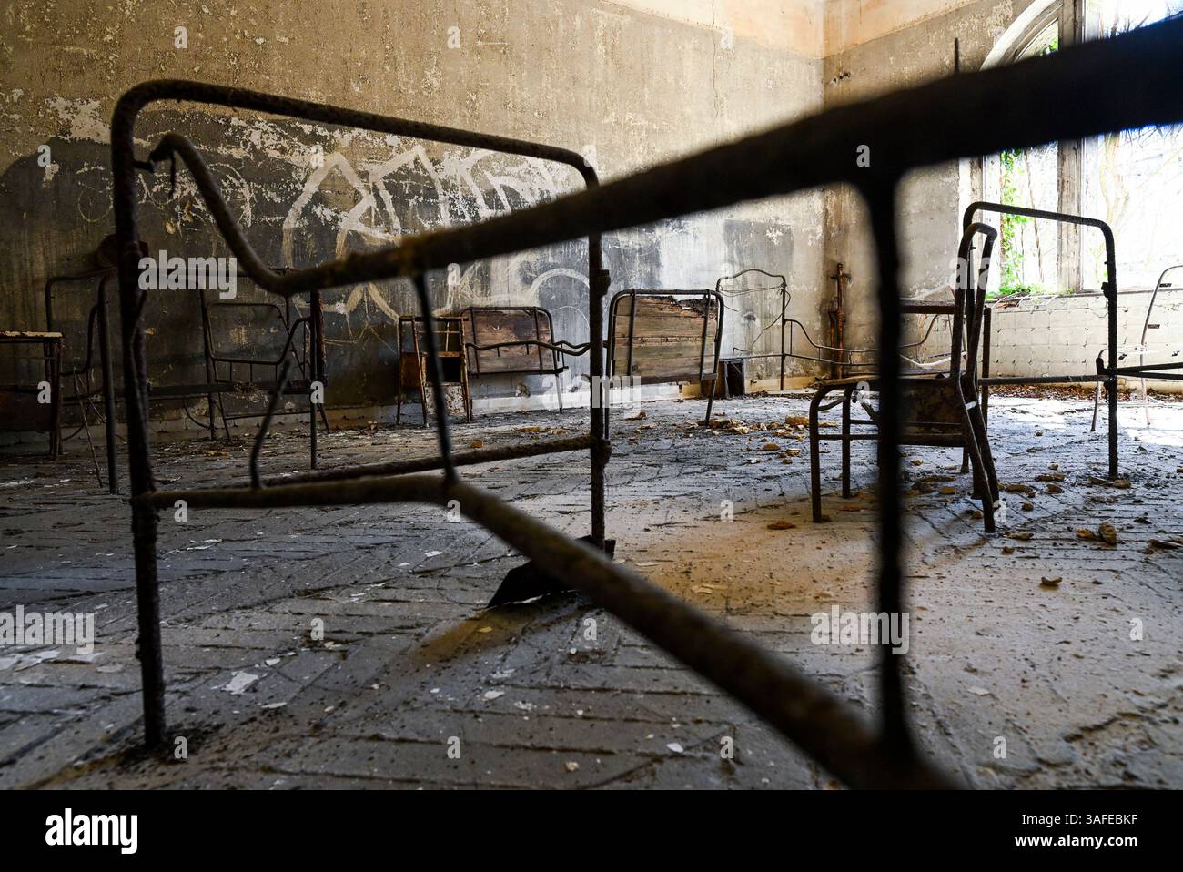 Beelitz, Deutschland. April 2025. Überreste von Patientenbetten sind im baufälligen Alpenhaus auf dem Gelände des ehemaligen Lungenheilanatoriums in Beelitz-Heilstätten zu sehen. Der weitläufige Gebäudekomplex wurde Ende des 19. Jahrhunderts errichtet. Heute ist es vor allem für seine verlassenen und teilweise baufälligen Gebäude bekannt, die Fotografen, Touristen und Filmteams anziehen. Russische Soldaten waren hier von 1945 bis zum Abzug der sowjetischen Truppen aus Deutschland 1994 stationiert. Quelle: Jens Kalaene/dpa/Alamy Live News Stockfoto