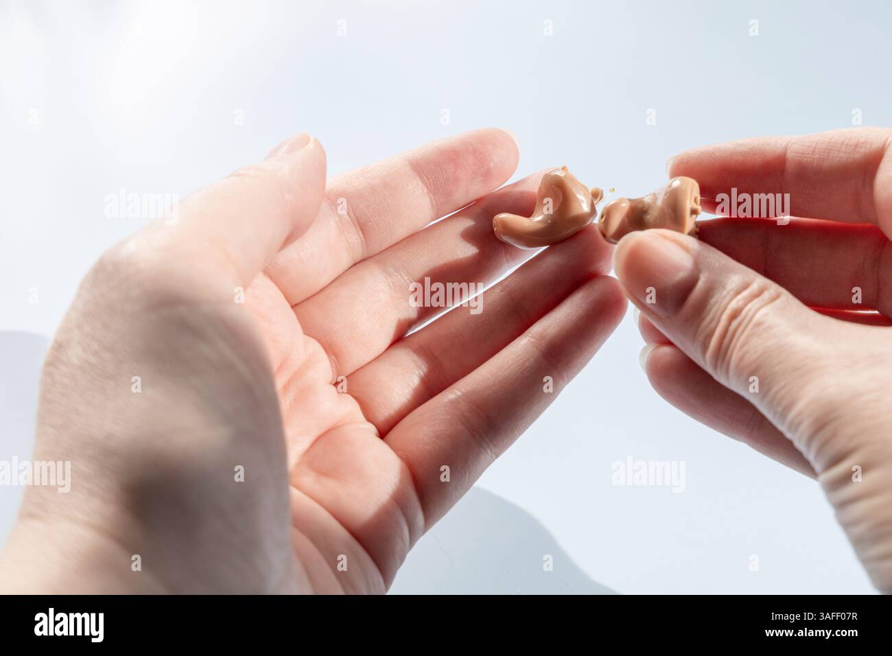 Arzt hält modernes Hörgerät. Hörlösungen. Stockfoto