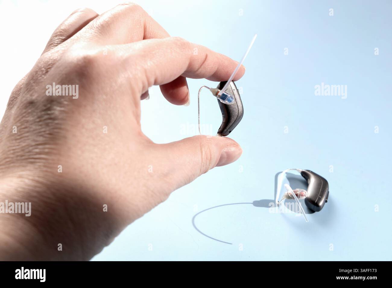 Arzt hält modernes Hörgerät. Hörlösungen. Stockfoto