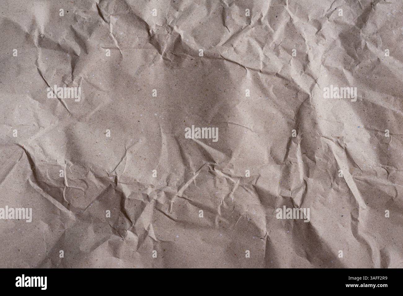 Zerknitterte braune Papierstruktur, natürliche Falten, Faserdetails. Bastelpapier Hintergrund, umweltfreundliches Design Stockfoto