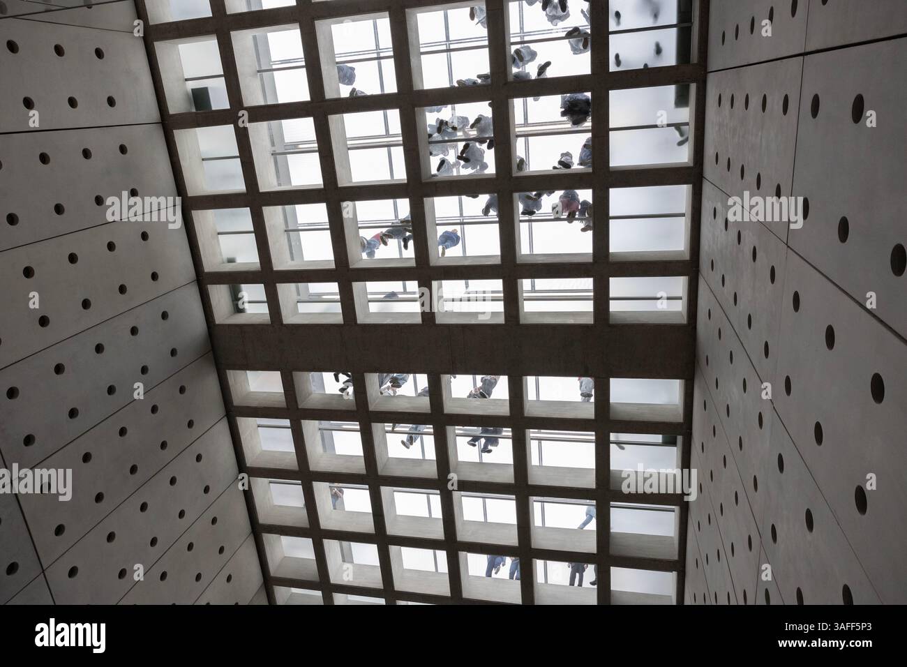 Blick von unten auf Menschen, die auf dem Glasboden des Akropolis-Museums laufen, entworfen von Bernard Tschumi in Athen, Griechenland. Stockfoto