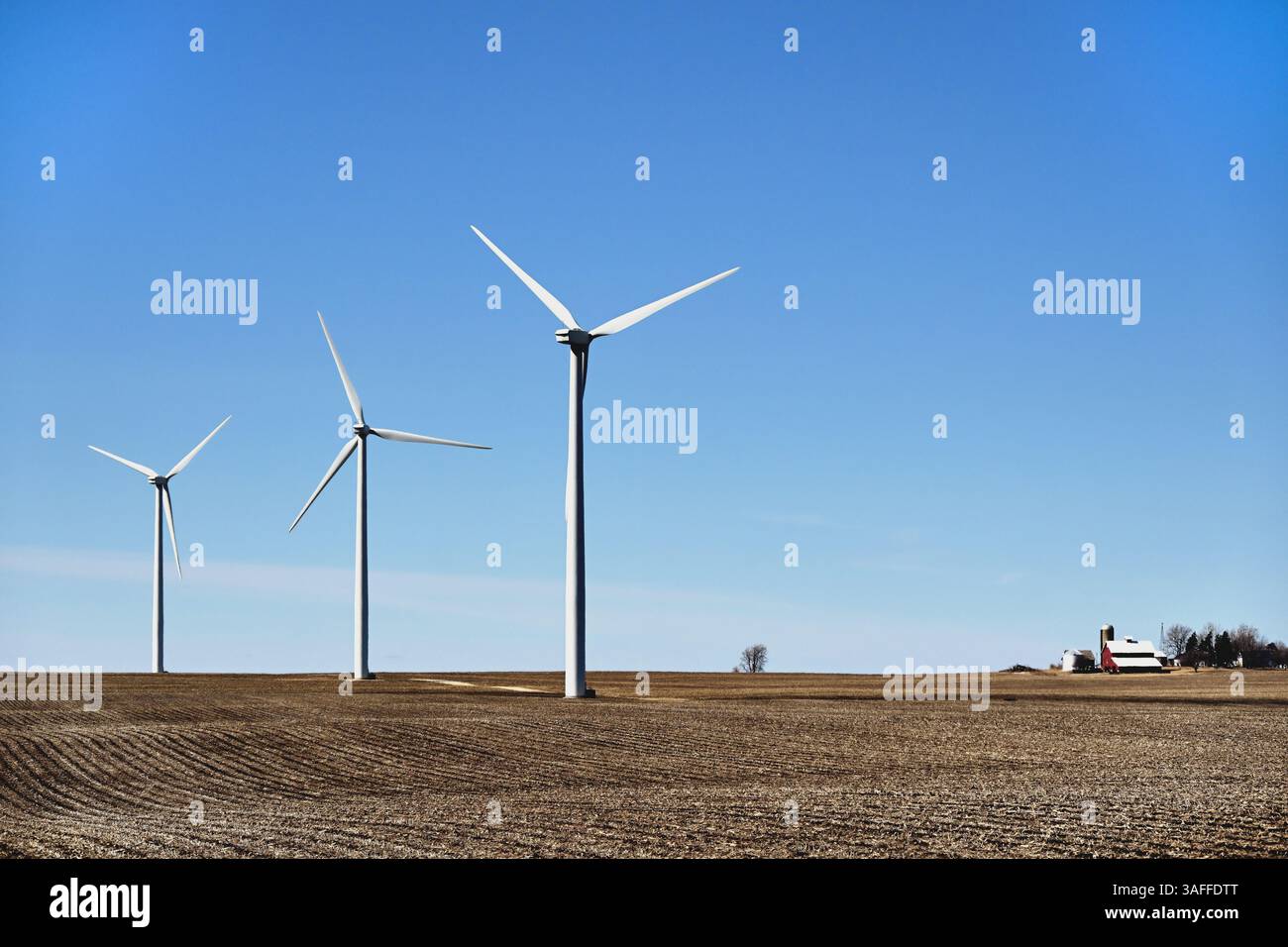Paw Paw, Illinois, USA. Windturbinen verkleinern weit entfernte Betriebsstrukturen, da sie nicht durch Feldfrüchte verdeckt sind. Stockfoto