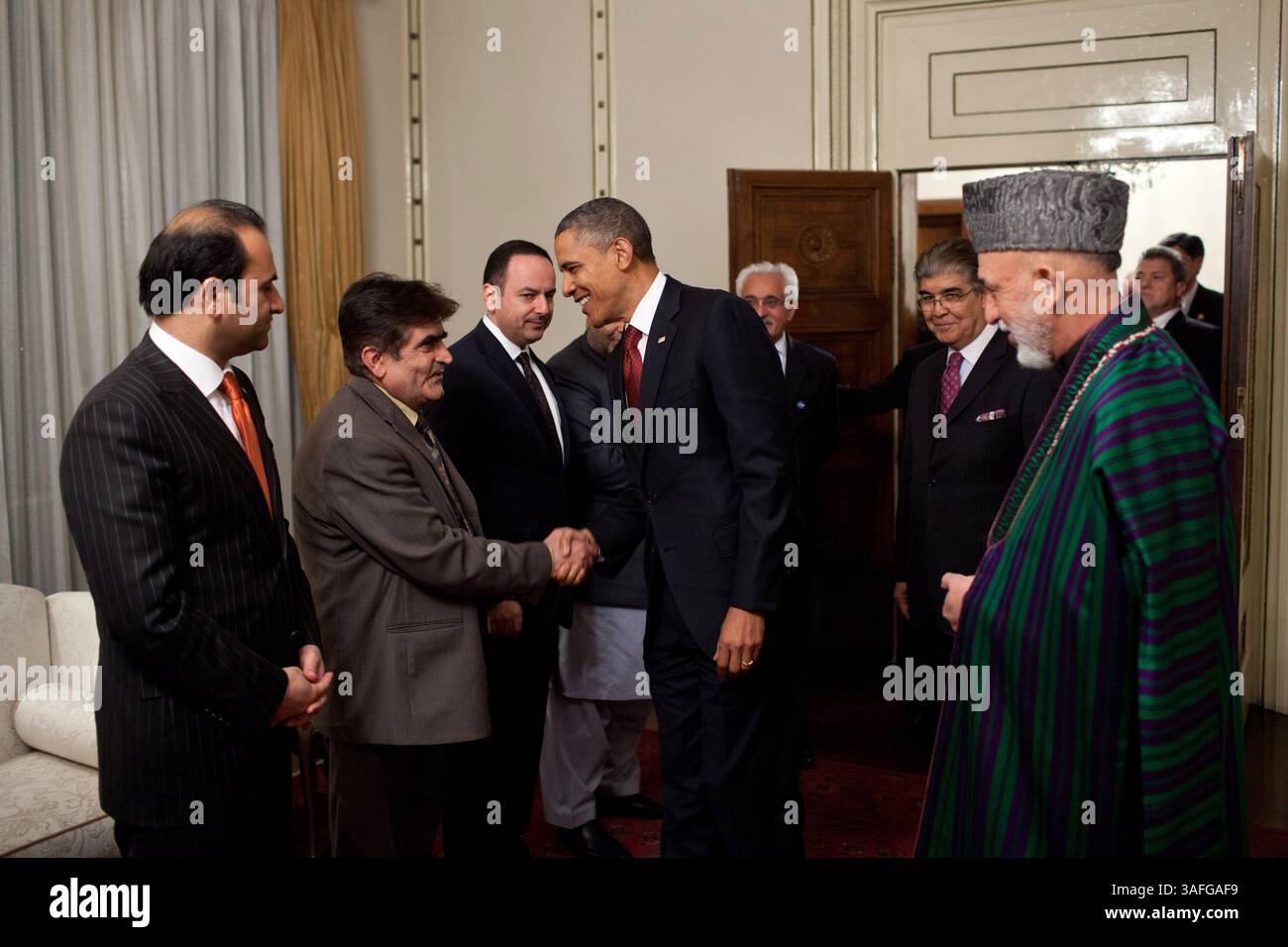 1. Mai 2012 - Kabul, Afghanistan - Präsident BARACK OBAMA begrüßt Mitglieder der afghanischen Delegation, während Präsident HAMID KARZAI im Präsidentenpalast in Kabul, Afghanistan, beobachtet. Präsident Barack Obama bezeichnete den Todestag von Osama bin Laden mit einer schnellen Reise nach Afghanistan, unterzeichnete am Mittwoch einen strategischen Pakt mit Kabul und übermittelte den Amerikanern im Wahljahr die Botschaft, dass der Krieg zum Ende geht. Kurz nachdem Obama und der afghanische Präsident Hamid Karzai unter dem Schutz der Dunkelheit angekommen waren, unterzeichneten sie eine strategische Partnerschaftsvereinbarung im Palast des afghanischen Führers, die eine vorsieht Stockfoto