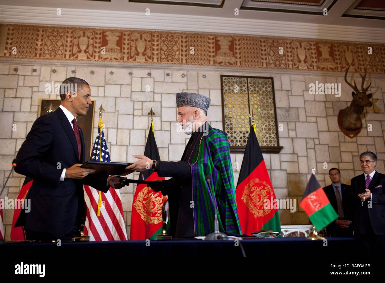 1. Mai 2012 – Kabul, Afghanistan – Präsident BARACK OBAMA und afghanischer Präsident HAMID KARZAI tauschen Dokumente aus, nachdem sie die Unterzeichnung der strategischen Partnerschaftsvereinbarung im Präsidentenpalast in Kabul, Afghanistan, unterzeichnet haben. Präsident Barack Obama bezeichnete den Todestag von Osama bin Laden mit einer schnellen Reise nach Afghanistan, unterzeichnete am Mittwoch einen strategischen Pakt mit Kabul und übermittelte den Amerikanern im Wahljahr die Botschaft, dass der Krieg zum Ende geht. Kurz nachdem Obama und der afghanische Präsident Hamid Karzai unter dem Deckmantel der Dunkelheit angekommen waren, unterzeichneten sie ein strategisches Partnerschaftsabkommen Stockfoto