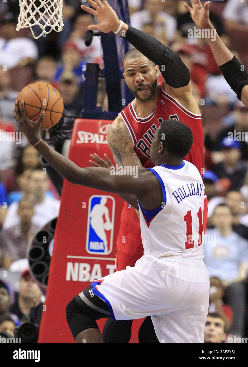 6. Mai 2012 - Philadelphia, PA, USA - die Philadelphia 76ers' Jrue Holiday (11) erzielt trotz des Drucks von Chicago Bulls-Verteidiger Carlos Boozer im vierten Quartal des Viertelfinals der NBA Eastern Conference im Wells Fargo Center in Philadelphia, Pennsylvania, Sonntag, 6. Mai 2012. Die Sixers besiegten die Bulls zwischen 89 und 82. (Bild: © Ron Cortes/Philadelphia Inquirer/MCT/ZUMAPRESS.com) Stockfoto