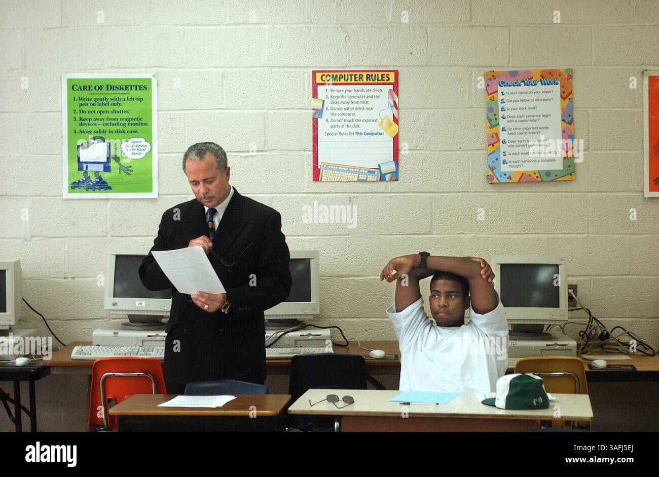 Andre Hornsby, der neue CEO der Prince George's County Public Schools, sieht sich die Zeitung des Suitland High School Schülers Aaron Sawyer, 17, an, als er am Montag, 25. August 2003 Betriebswirtschaftsunterricht besucht. Hornsby besuchte die Suitland High School am ersten Schultag in Forestville, MD. (Credit Image: The Washington Times/ZUMAPRESS.com) Stockfoto