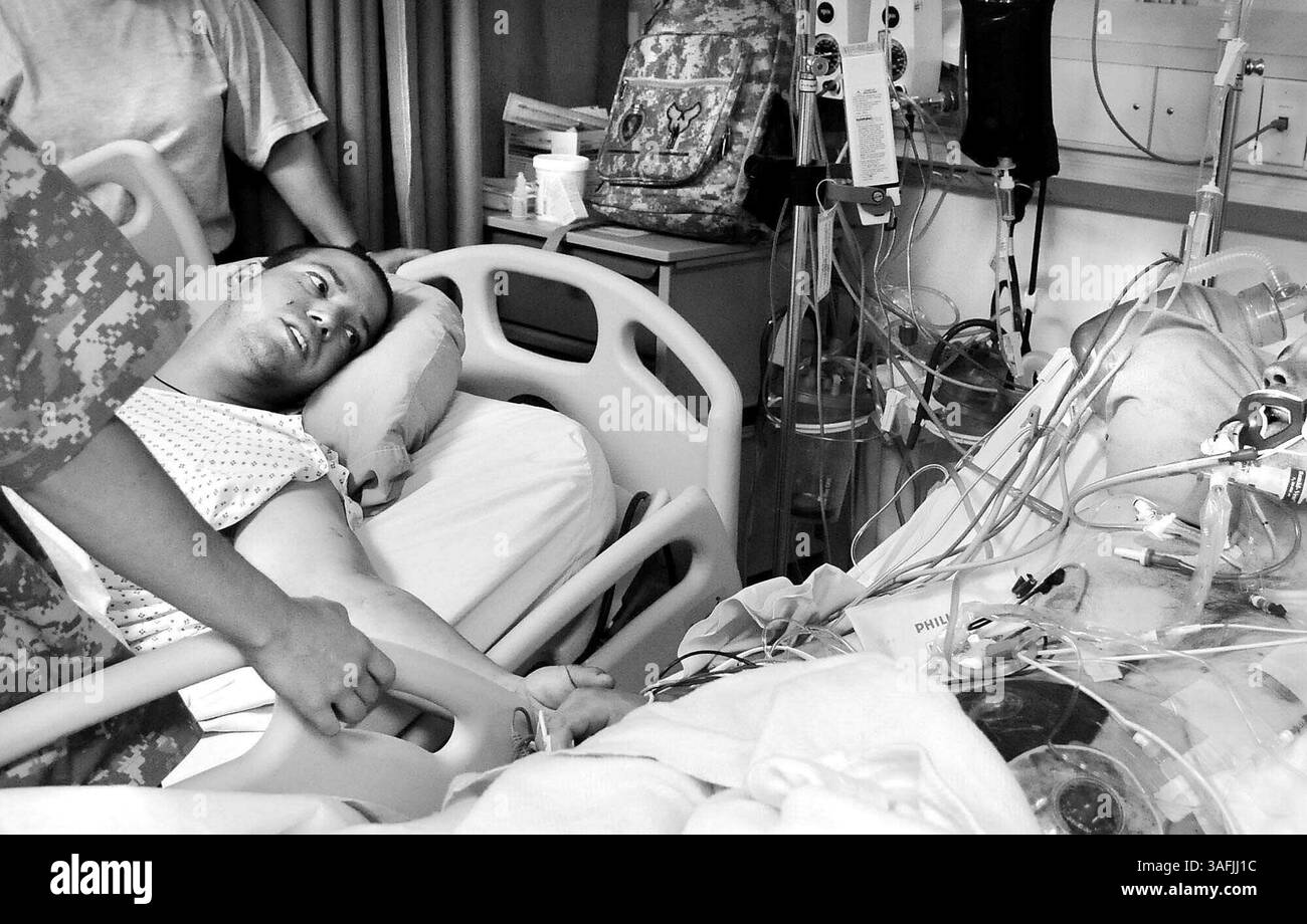 Sgt. First Class Pablo Cadena aus San Diego hält die Hand seines verwundeten Kumpels. "Ich bin froh, dich zu sehen, Mann. Denk nur daran, wir können bald nach Hause gehen. Wir fliegen morgen ab... passen Sie auf sich auf“, sagte Cadena dem Soldaten auf der Intensivstation des Craig Joint Theatre Hospital auf der Bagram Air Force Base am Montag, 2. Juni 2008 (Credit Image: The Washington Times/ZUMAPRESS.com). Stockfoto