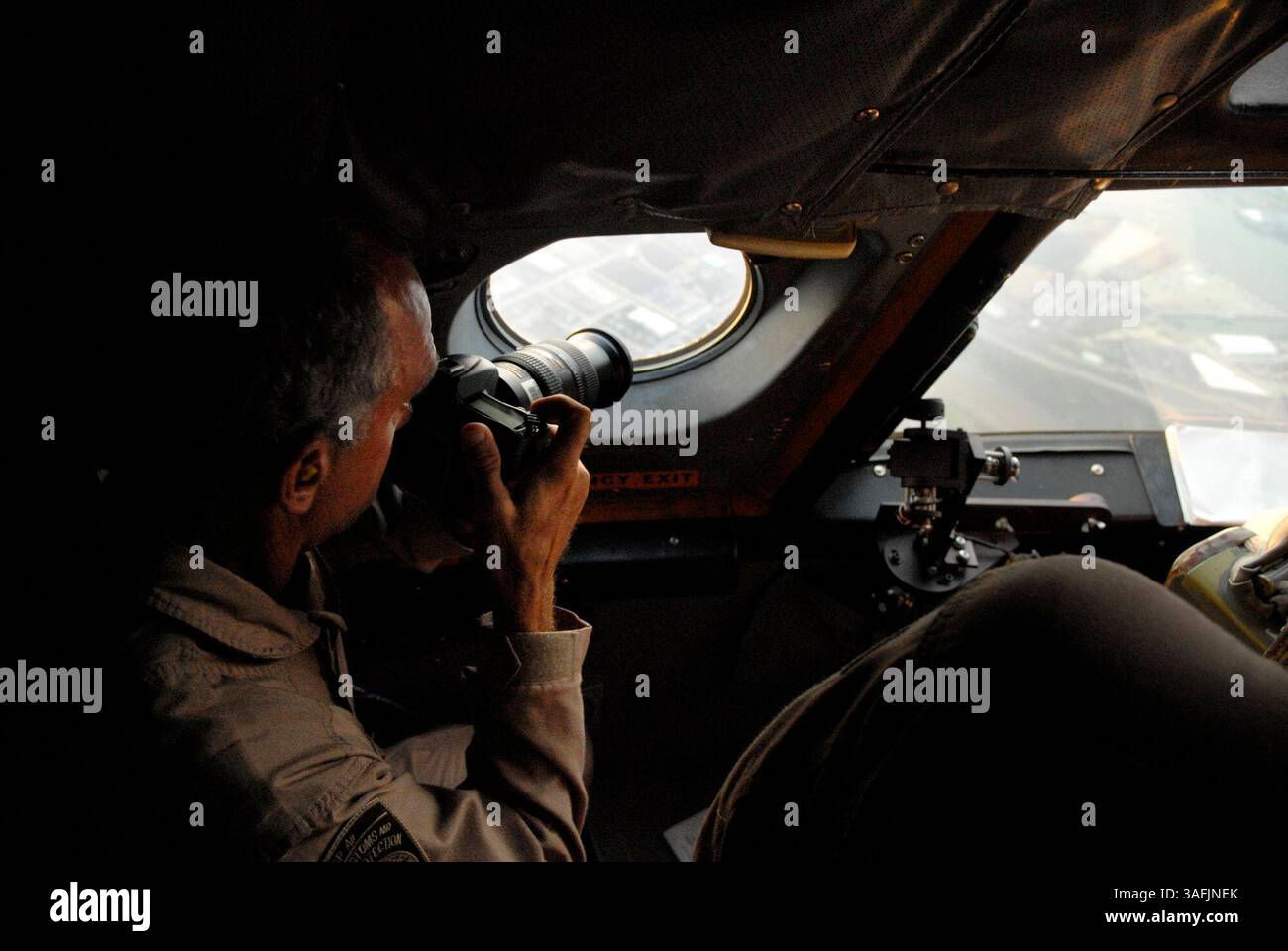 An Bord der P-3 Orion Long Range Tracker macht Dan Busse Fotos von interessanten Orten, während er und die Besatzung über die texanische Küste des Golfs von Mexiko in Gebieten fliegen, die vom Hurrikan Ike am Sonntag, den 14. September 2008 schwer getroffen wurden. Die Aufgabe der Crew ist es, Fotos und Videos von den Schäden bestimmter Ziele zu erhalten, wie es von der Federal Emergency Management Agency benötigt wird (Credit Image: The Washington Times/ZUMAPRESS.com) Stockfoto