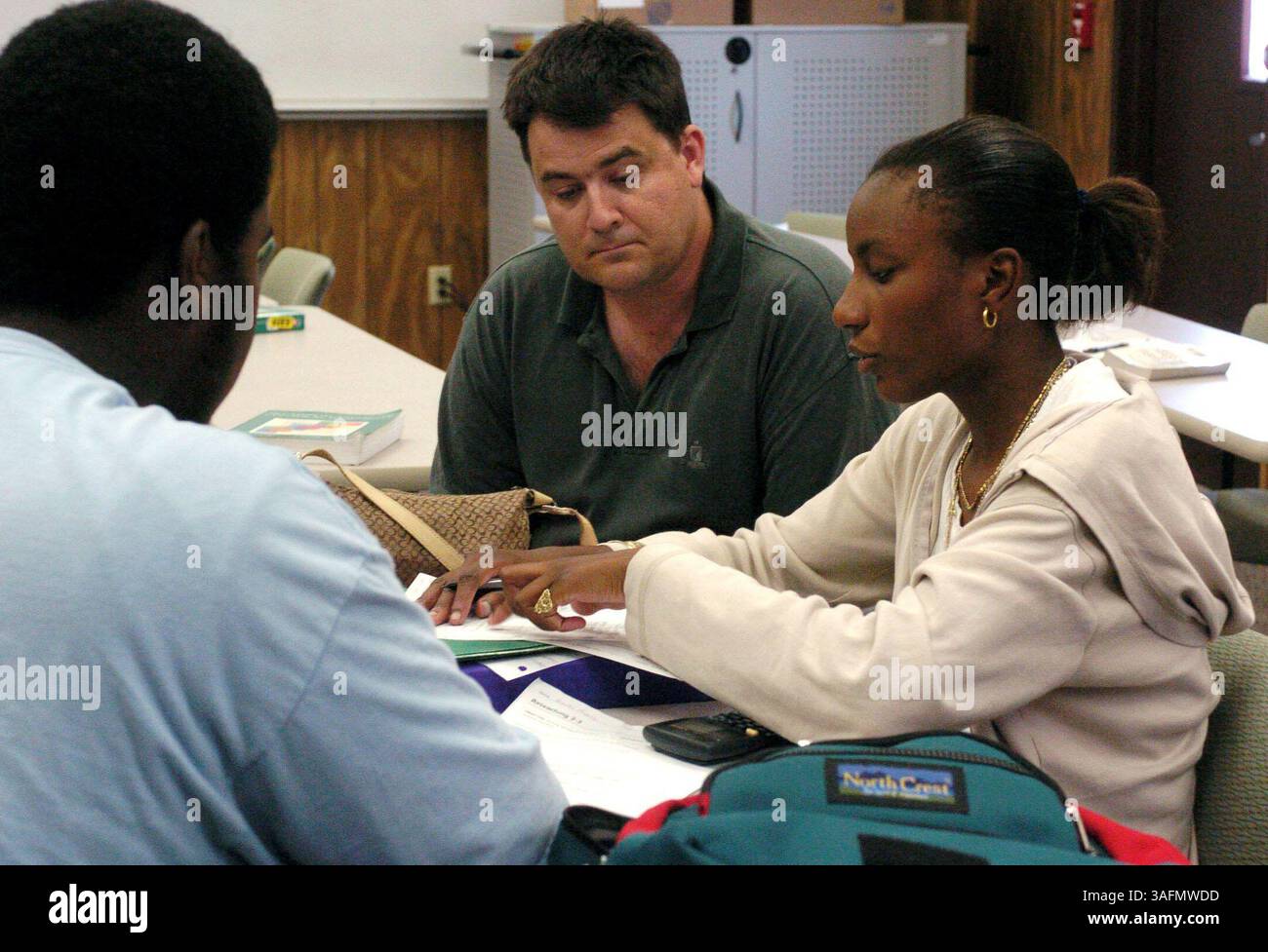 Weniger als zwei Monate nach ihrem Eröffnungsjahr hat die Direktorin Linda Benware begonnen, Studenten für das Jahr 2005-06 für die St. Petersburg Collegiate High School zu rekrutieren. Die neue Charterschule ermöglicht es Schülern der Klassen 10-12, zwei Jahre Gymnasium und zwei Jahre College gleichzeitig kostenlos zu absolvieren. Fotos wurden in der Schule am Donnerstag (16.09.04) gemacht.***Foto 1. Während eines Tutorings für Schüler von Algebra II hilft Chris Briden (cq), ein Mitarbeiter von Raytheon, der freiwillig an der Schule arbeitet, Rodrica Dixon (cq) bei ihrem Studium. Schauen Sie nach Branden Vazquez (Kreditbild: St. Petersburg Stockfoto