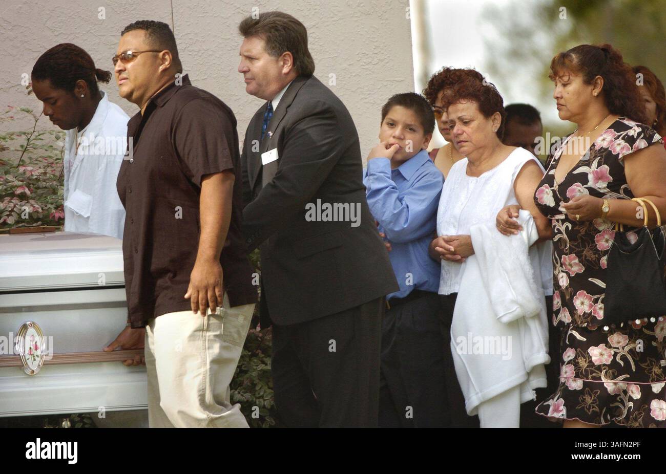 Bildunterschrift: Familienmitglieder (Mutter wird als zweitwichtigste von rechts angesehen, in weiß ð versucht zu bestätigen) gehen am Dienstagmorgen (23.11.04) hinter den Sarg von Joana Cruz (cq) in der katholischen Kirche der Verklärung in St. Petersburg vor dem Begräbnisgottesdienst. Cruz wurde am Donnerstag bei RadioShack erschossen (Credit Image: St Petersburg Times/ZUMAPRESS.com) Stockfoto