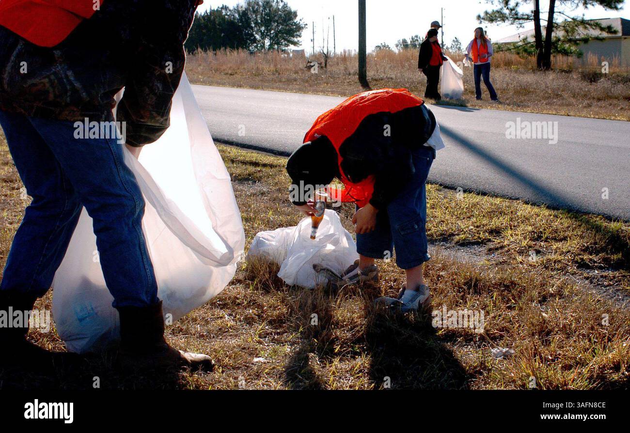 Hill 'n Dale, 12.2.2005: FOTO 1: Daniel Camp (CQ), 16, links, und Jeff Forelle (CQ-Center), 12, sammeln Sie Müll entlang des Wakefield Drive in Hill 'n Dale, Teil der jährlichen Operation P.R.I.D.E. Community Cleanup von 7 bis 10 Uhr am Samstag. Im Hintergrund arbeiten Cristyn Bearden (CQ-Cristyn), 15, Hernando County Commissioner Chris Kingsley und Jacklynn Ceronsky (CQ-Jacklynn Ceronsky-ganz rechts), 14, auf der gegenüberliegenden Straßenseite. Freiwillige räumten Flaschen und Müll vom Straßenrand ab und entsorgten sogar eine Autohaube, eine Autobatterie und einen benzinbetriebenen Roller. Einer der beunruhigendsten Funde W Stockfoto