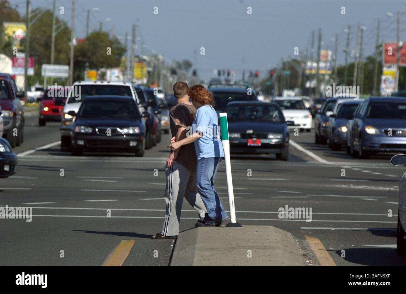 LARGO - 10.3.2005) BILDUNTERSCHRIFT: 1) Dean Gaesser (CQ), links, und Debbie Dubawsky (CQ) machen einen vorsichtigen Schritt in den letzten Abschnitt ihrer 30-Sekunden-Reise über die westwärts gerichteten Straßen des East Bay Drive an der Keene Road in Largo. Das Ehepaar überquert häufig die befahrene Straße, auf der in den letzten ein oder zwei Jahren mehrere Menschen bei Unfällen ums Leben kamen. Sie sagten, sie wurden fast von einem Auto angefahren, als sie vor einem Monat überquerten. "Wir überquerten uns auf halbem Weg, wir waren in der Mitte und jemand, der nach links abbiegte, sah uns nicht", sagte Gaesser. 'Dann hielten sie sehr schnell an, wir rannten den Rest des Weges, um dort rauszukommen.'' (Guthaben Stockfoto