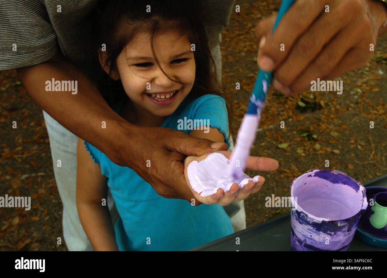 BILDUNTERSCHRIFT: (St. Petersburg, 28.03.2005). ZUSAMMENFASSUNG DER GESCHICHTE: Mylilani Sample, 5, (cq) lacht, weil der Pinsel ihre Hand kitzelt, während sie Hilfe beim Drucken eines Handabdrucks bei Academy of Learning, Inc. Bekommt Montag in St. Petersburg. Im Rahmen der Kinderwoche werden Handabdrücke von Kindern im Pinellas County gesammelt und zu Handabdrücken im ganzen Land hinzugefügt, die in der Capitol Rotunde in Tallahassee gehängt werden. (Bild: St. Petersburg Times/ZUMAPRESS.com) Stockfoto