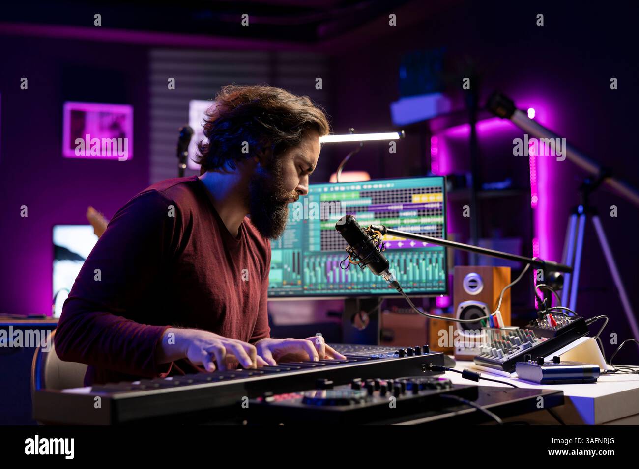 Toningenieur arbeitet im Heimstudio mit daw Software-Schnittstelle, spielt Klaviernoten ab und bearbeitet Audioaufnahmen. Interpret erstellt Melodien auf der elektronischen Midi-Controller-Tastatur. Stockfoto