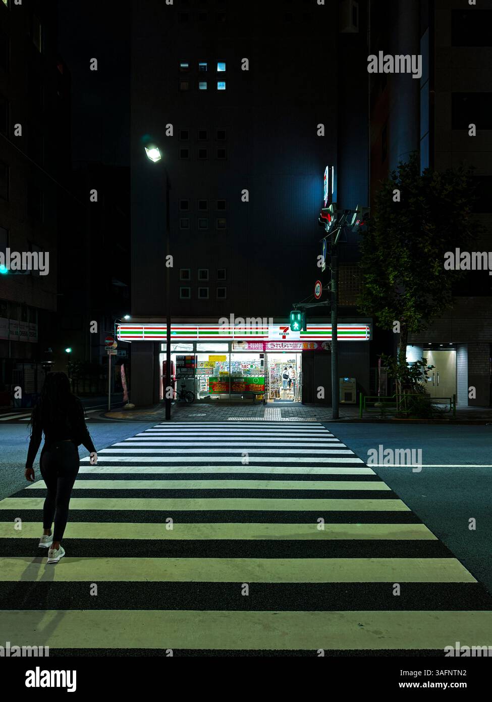 Über die Straße zu einem 24-Stunden-Geschäft von 7/11 in Tokio, Japan - Smartphone-aufgenommenes Stockfoto