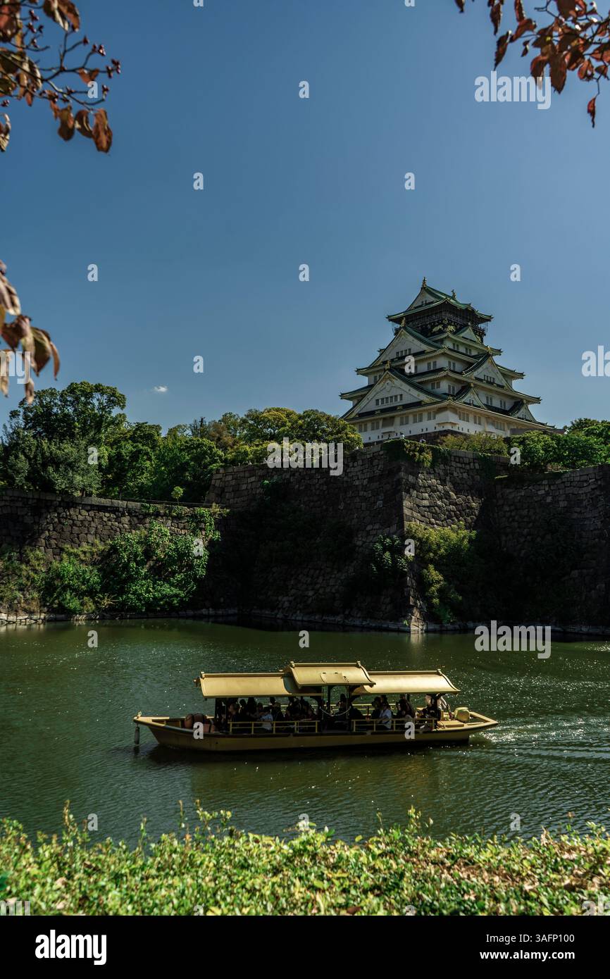 Flussboot, das auf dem Graben auf der Burg Osaka in Osaka, Japan, fährt Stockfoto