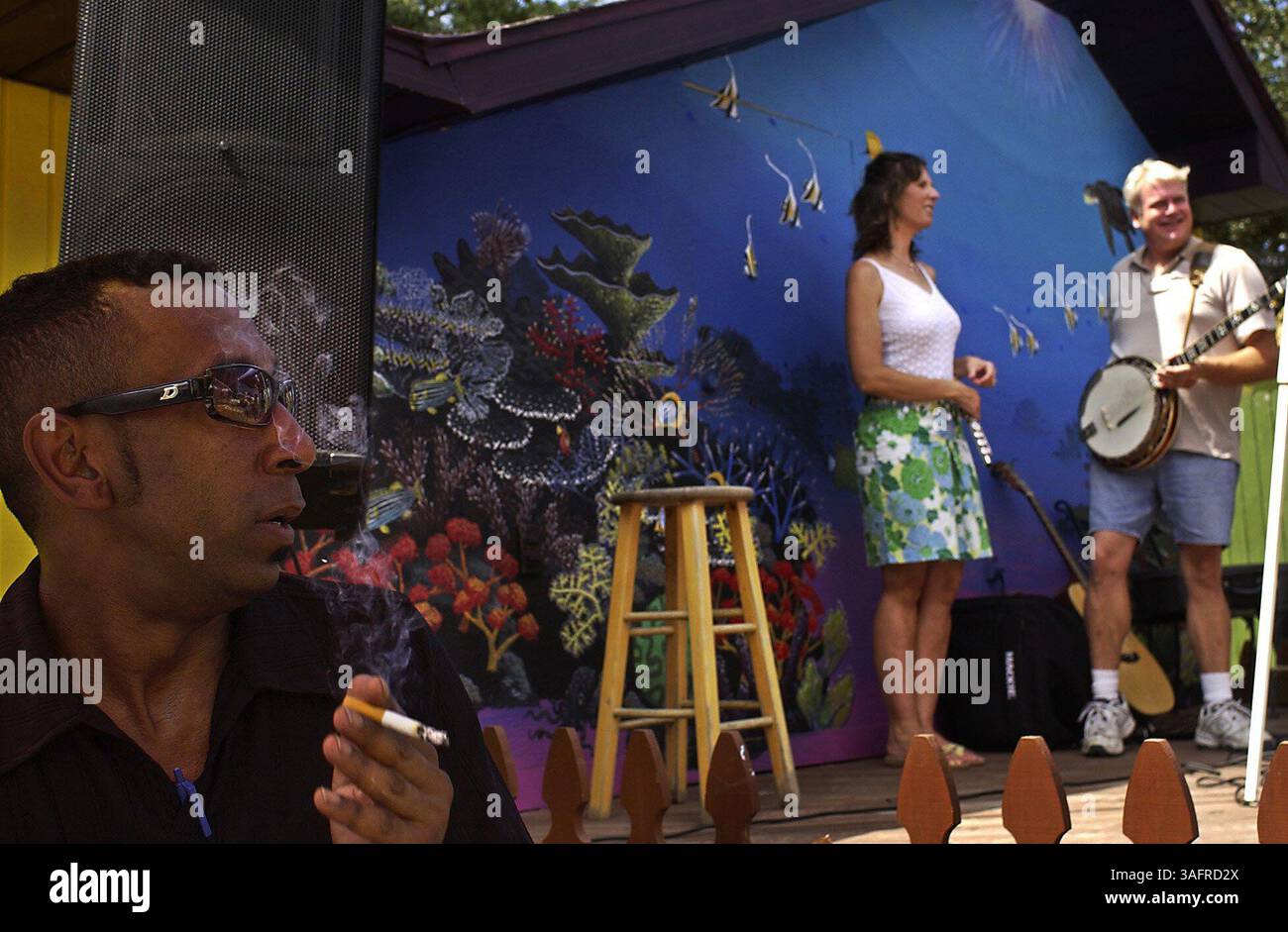 BILDUNTERSCHRIFT: (Gulfport, 10.09.2005) Katrina evakuiert Eric Brown (cq-links), aus New Orleans, gestoppt am Gulfport, FL nach Gulfport, MS-Hilfskonzert im Art Village Courtyard Samstag (10.09.2005), als Kristen Holloway (cq) und Michael Godwin (cq) von der Band Gypsy Wind sich bereit machten, die Bühne zu nehmen. Brown verbrachte vier Tage auf seinem Dach, bevor er ausschwamm und sich zum Superdome machte und schließlich in einen Bus nach Dallas stieg. Seine Familie in Kalifornien half ihm, ein Ticket nach Tampa zu kaufen, und er wohnt derzeit bei Menschen in St. Petersburg. Eine Freundin, die er gemacht hat, Diane Bower (Credit Image: S Stockfoto