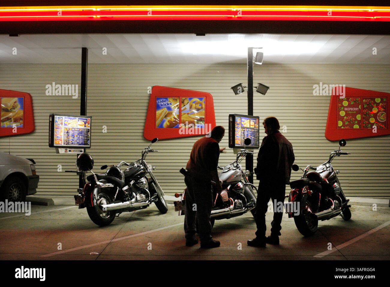 BILDUNTERSCHRIFT: (11/02/2005 Spring Hill) L-R: Tim Yates (cq vom Thema), 51, von New Port Richey und Dan Eslinger (cq vom Thema), 49, von Hudson, schauen Sie sich eine Reihe von Motorrädern beim Spring Hill Sonic Drive in am 2. November 2005 bei der wöchentlichen Fahrradnacht im Fast-Food-Restaurant an. Manche Leute kommen jede Woche zum Fahrradabend. Das war Yates' erstes Mal. "Ich sagte Hime, er solle hier raufkommen und es überprüfen", sagt Eslinger. (Bild: St. Petersburg Times/ZUMAPRESS.com) Stockfoto
