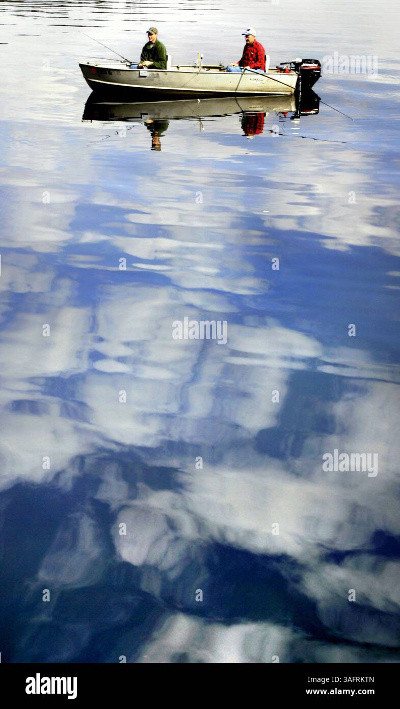 BILDUNTERSCHRIFT: (10.01.2006, HERNANDO) Travis Goodman, 18, of Crystal River, links, wartet auf einen Biss, als Lee Isom (cq) aus Inverness sein kleines Fischerboot zwischen den Spiegeln der Cumulus-Wolken manövriert, während er auf den ruhigen Gewässern des Hernando-Pools der Tsala Apopka-Seenkette in Hernando fischt Dienstag (10.01.2006) Morgen. „Wir fischen nur und haben Spaß“, sagte Isom, als sie sich auf der glasreichen Oberfläche des Sees niederschlossen. „Der Wind ist heute fast zu still.“ ZUSAMMENFASSUNG DER GESCHICHTE: Eigenständige Angelfunktion. (Bild: St. Petersburg Times/ZUMAPRESS.com) Stockfoto