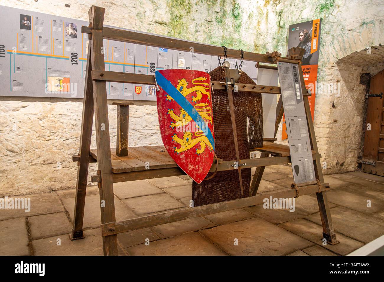 Ein Schild hängt an einem Waffenständer in Kidwelly Castle in Camarthanshire, Wales, Großbritannien Stockfoto