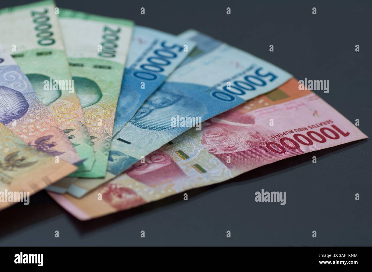 Verschiedene indonesische Rupiah-Banknoten auf dunklem Hintergrund Stockfoto