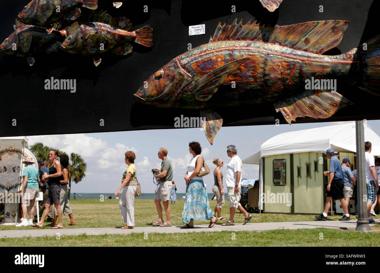 BILDUNTERSCHRIFT: (St. Petersburg, 21.04.2007) Eine Fischskulptur aus Kupfer hängt am Stand von Kevin Jenkins beim 32. Jährlichen Mainsail Art Festival im Vinoy Park Samstag (21.04.2007). Der 56-jährige Homosassa-Künstler wuchs in St. Petersburg auf und verkaufte sein erstes Stück im Alter von 16 Jahren – eine 1,80 m hohe Stahlente, die er als halb Huhn und halb Ente bezeichnet, die er im Kunstunterricht an der Dixie Hollins High School gemacht hat. Laut Jenkins Website verwendet er eine Technik im Stil eines Kupferschmieds: „Erhitzen, Hämmern und Schweißen oder Schmieden von Kupferblech und Stangenmaterial zu Fischen aller Größen und Arten“. (Kredit Ima Stockfoto