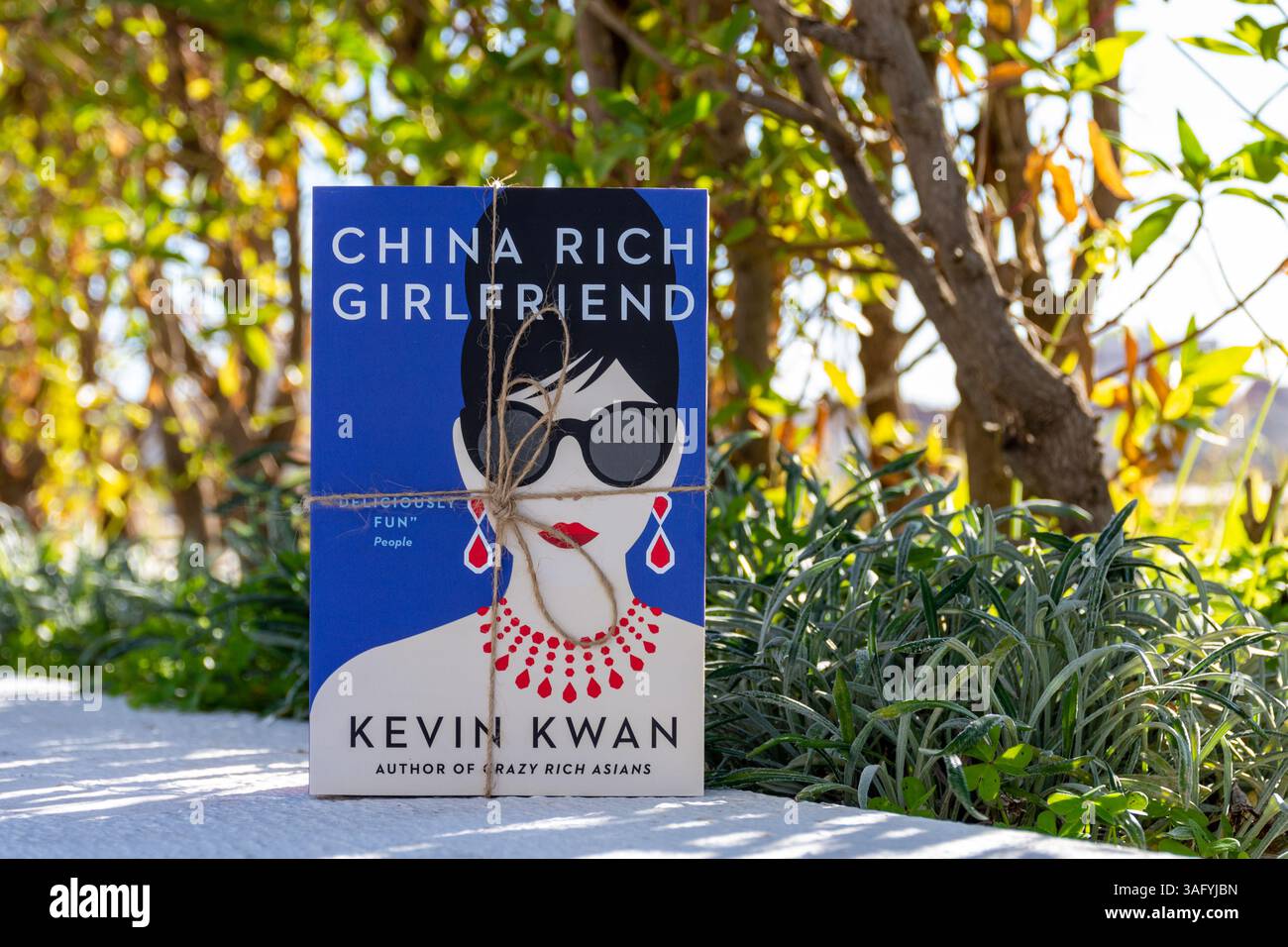 Close-up von Kevin Kwans China Rich Girlfriend Roman im Garten. Romantischer Comedy-Roman. Stockfoto