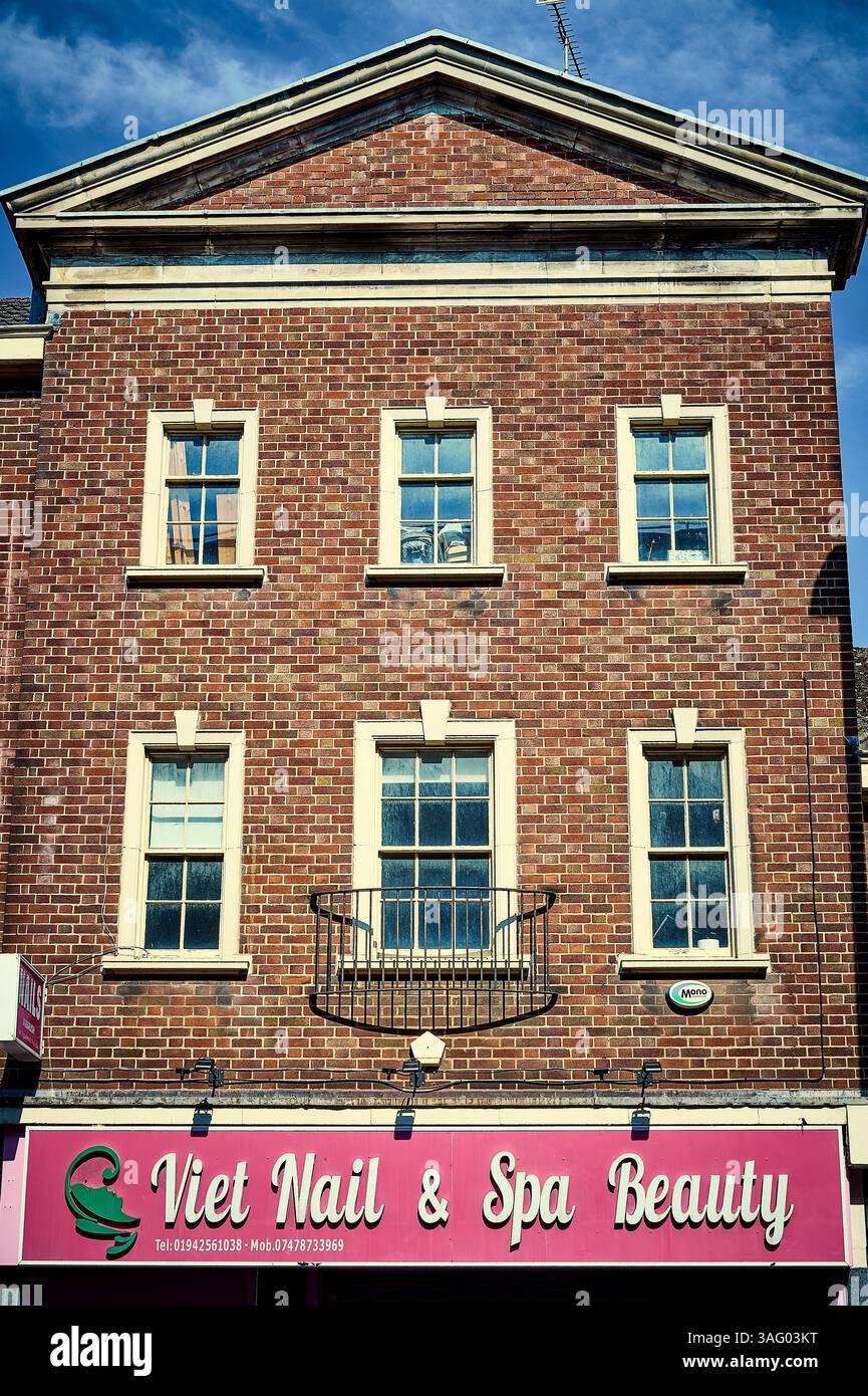Gebäude im Regency-Stil und rosa Nagel- und Spa-Schild, Wigan, UK Stockfoto
