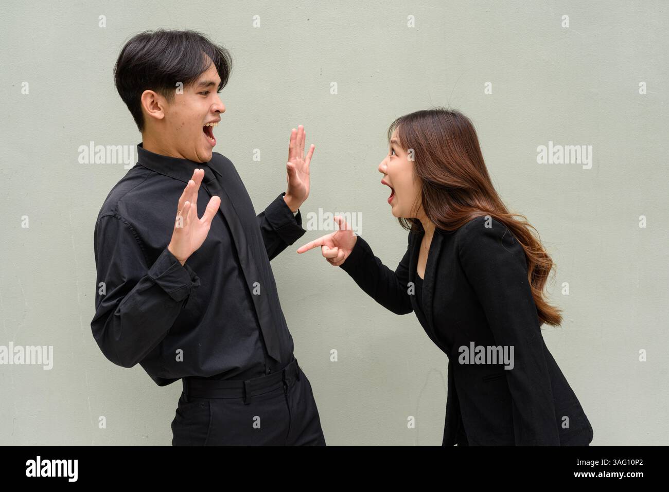 Porträt eines jungen asiatischen Paares, das Geschäftsuniform vor klarem Hintergrund trägt Stockfoto