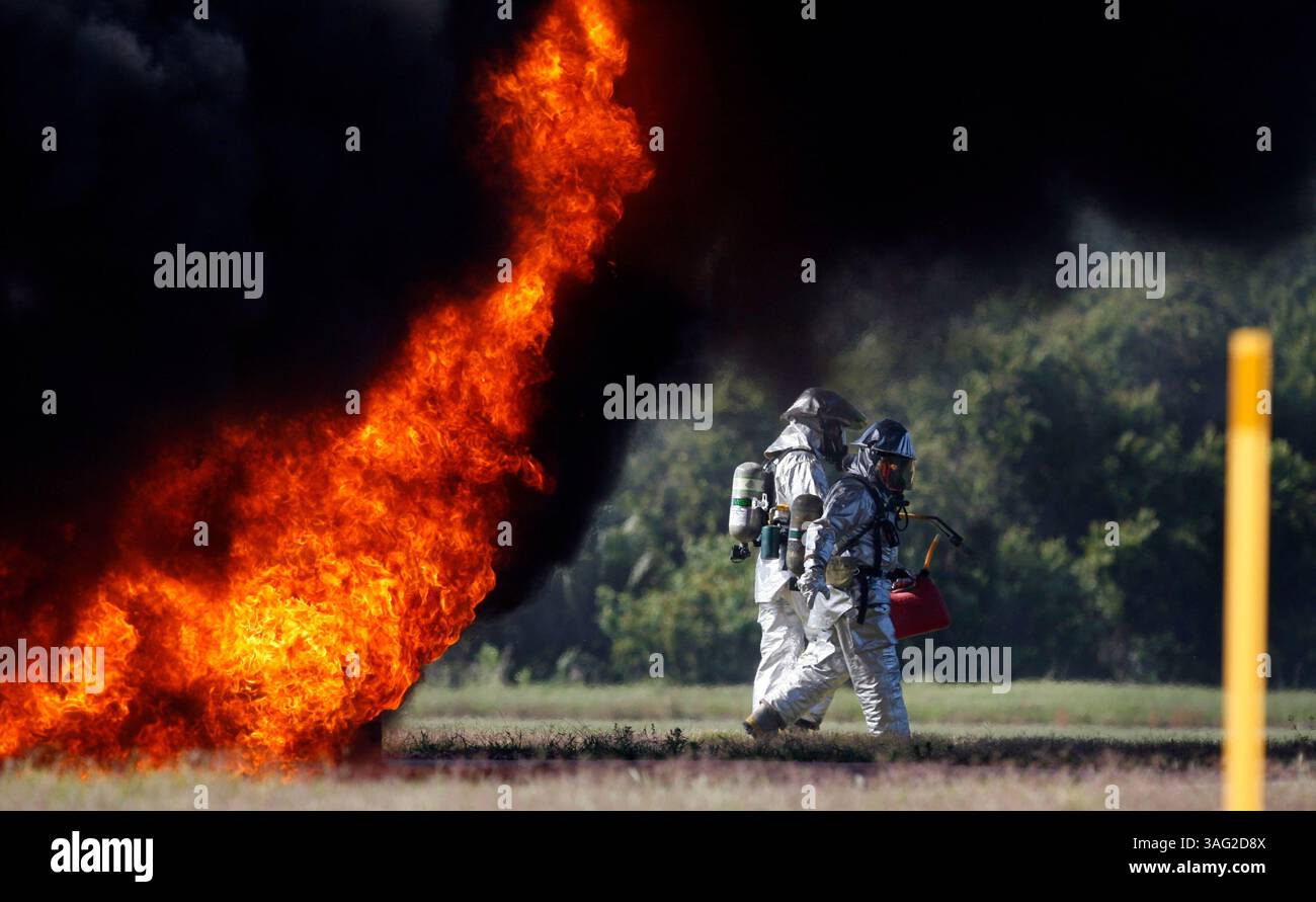Tampa 17.04.08)--1) Feuerwehrleute mit der Tampa Feuerwehr gehen zurück zu ihrem Truck, nachdem sie einen Brand auf einem leeren Abschnitt eines Flugzeugs begonnen haben. Der internationale Flughafen Tampa führte seine dreijährliche umfassende Notfallübung in Übereinstimmung mit den Federal Aviation Regulations durch. Nachdem die Feuerwehrfahrzeuge das Feuer gelöscht hatten, machten sie sich auf den Weg zum Delta Airlines Maintenance Hangar, wo eine Triage und eine Dekontaminationseinheit eingerichtet wurden. Schüler der Chamberlain High School fungierten als Opfer des simulierten Flugzeugabsturzes. (Bild: St. Petersburg Times/ZUMAPRESS.com) Stockfoto
