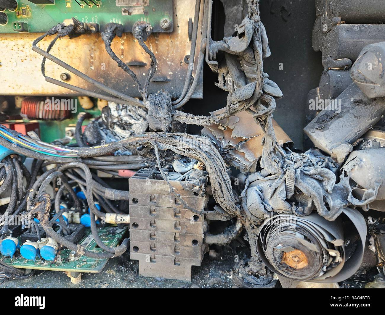 Beschädigter Solarwechselrichter nach Explosion – Nahaufnahme verbrannter Kondensatoren und geschmolzener interner Komponenten Stockfoto