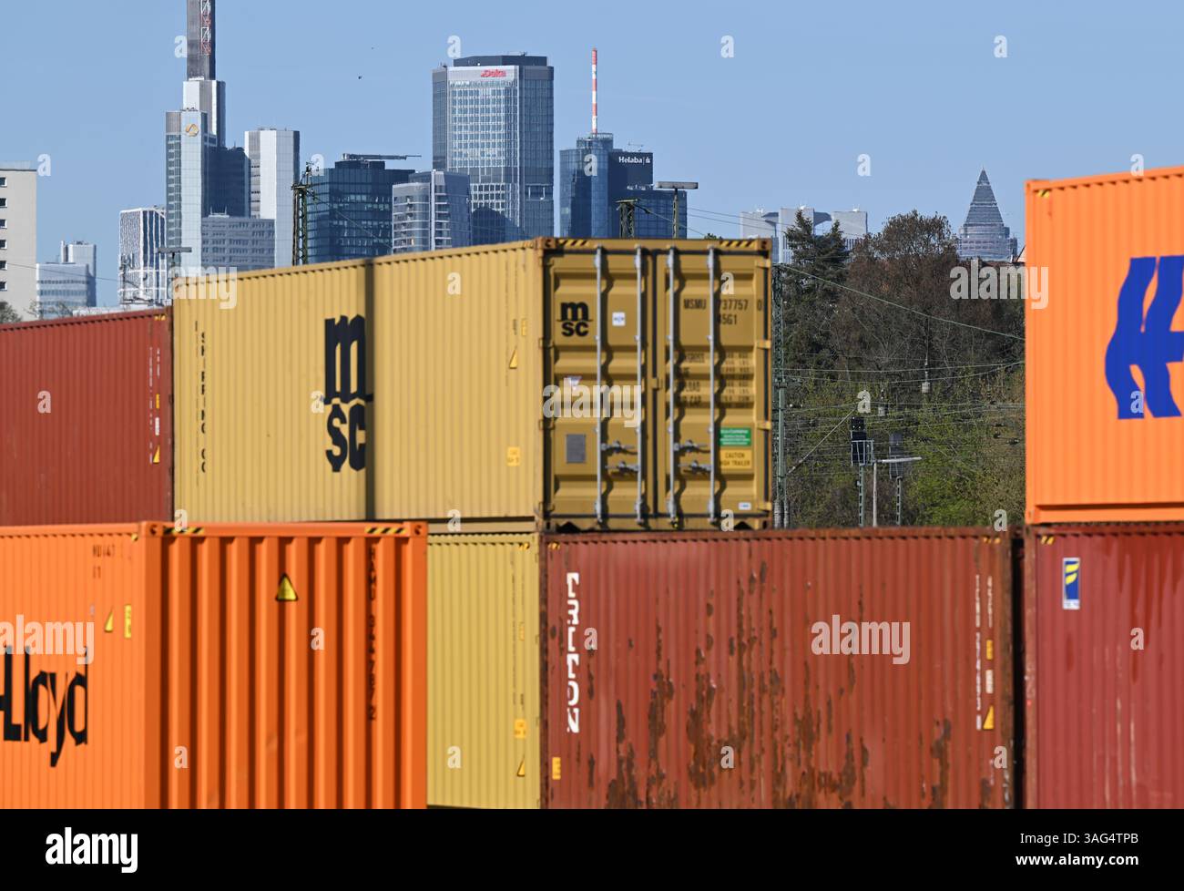08. April 2025, Hessen, Frankfurt/Main: Im Osten der Bankenstadt werden Gütercontainer auf dem Gelände des Umschlagbahnhofs DB gestapelt. Die Wolkenkratzer der Bank-Skyline erheben sich hinter ihnen. US-Präsident Trumps aggressive US-Zollpolitik kann auch als Handelskrieg gegen den Rest der Welt angesehen werden. Nach drei Tagen des Handels mit dem Rot startete der DAX am Dienstag wieder höher. Foto: Arne Dedert/dpa Stockfoto