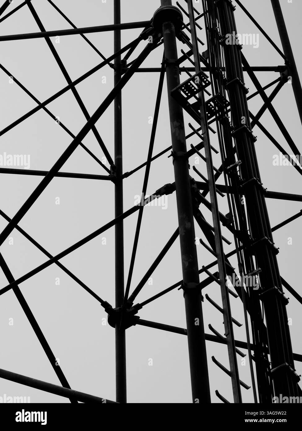 Ein zarter Stahlgitter-Funkturm erhebt sich mit schlanken Balken in den Himmel. Oben eine Plattform für Senderinstallationen Stockfoto