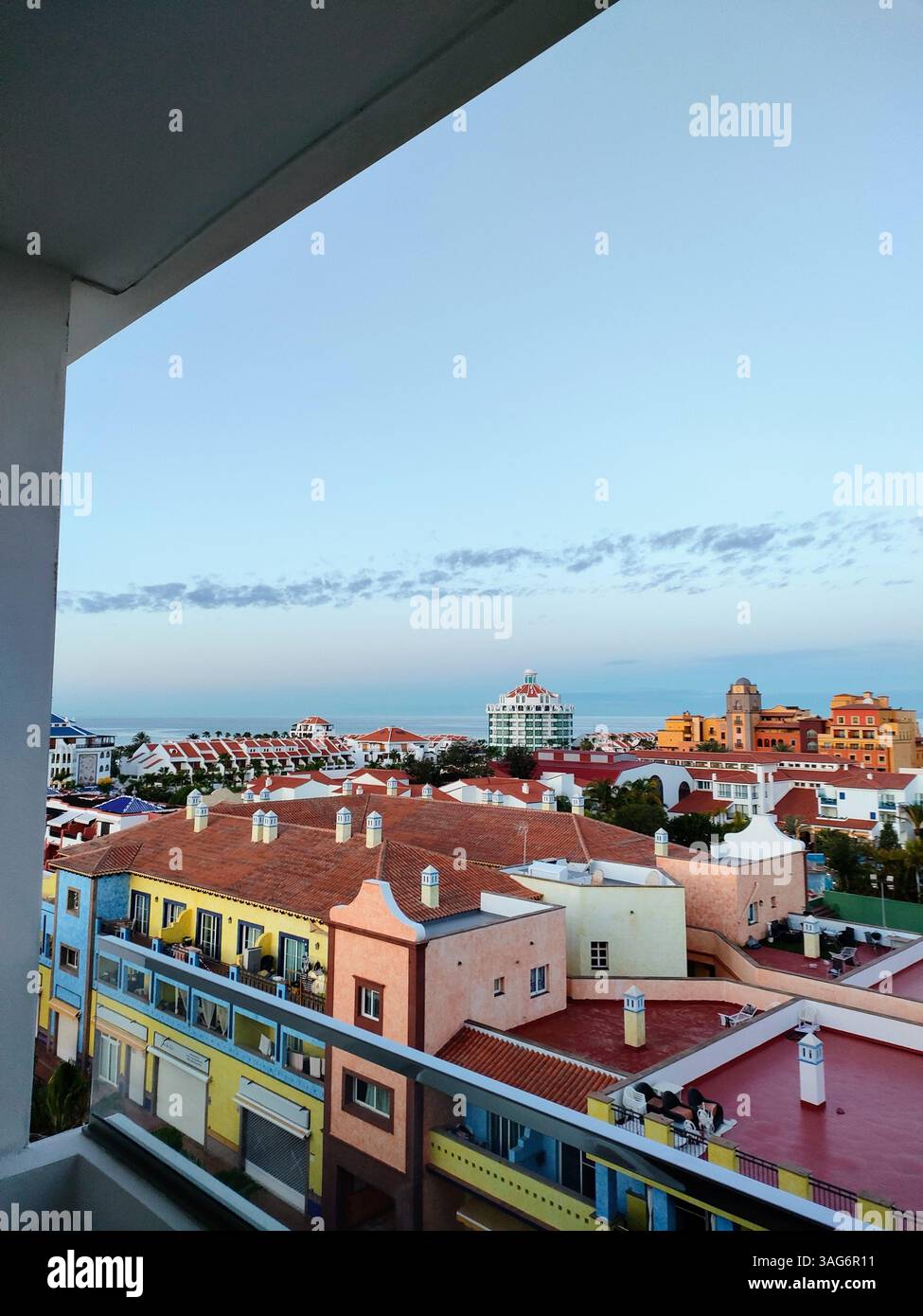 Erhöhter Blick über Playa de las Américas auf Teneriffa mit farbenfrohen Dächern, Himmel am frühen Morgen und einem friedlichen Küstenhorizont in der Ferne. - Smartphone-aufgenommenes Stockfoto