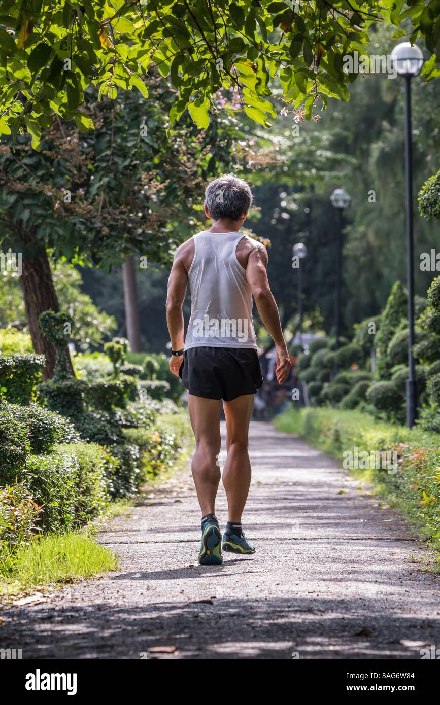 Älterer Mann Jogger sein Jogginglauf auf der Straße Läufer in einem Outdoor Park für Bewegung gesund Stockfoto