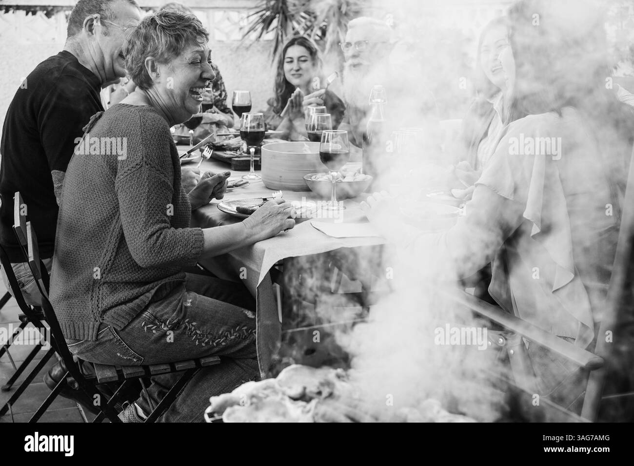 Glückliche Familie beim gemeinsamen Barbecue-Abendessen im Freien - verschiedene Altersstufen der Menschen, die Spaß am sonntagsgrillen haben - Essen, Geschmack und Sommerkonzept Stockfoto