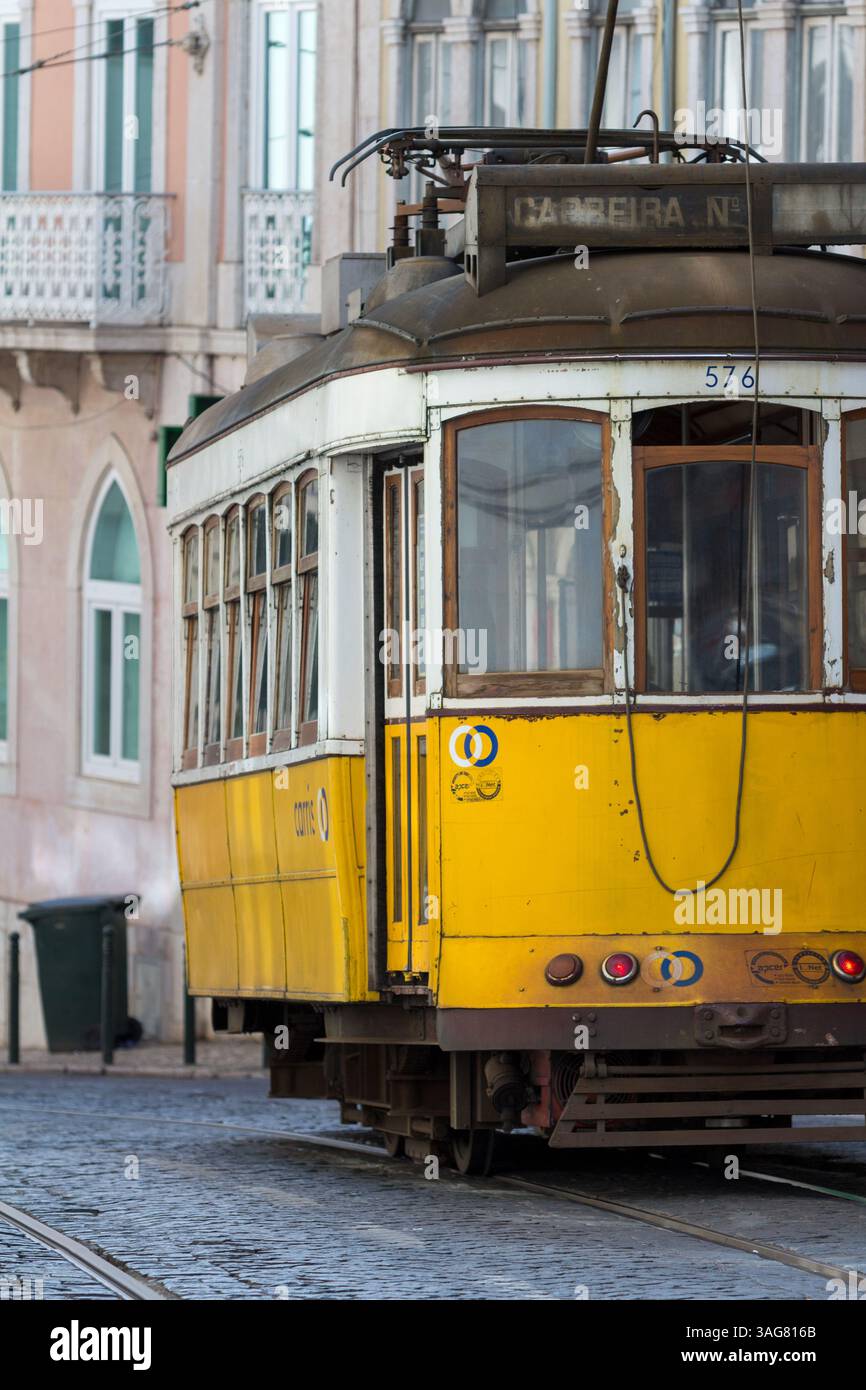 Nahaufnahme der berühmten gelben Straßenbahn Lissabons auf Kopfsteinpflasterstraßen mit Vintage-Details und klassischem Charme im historischen Stadtzentrum Portugals. Stockfoto