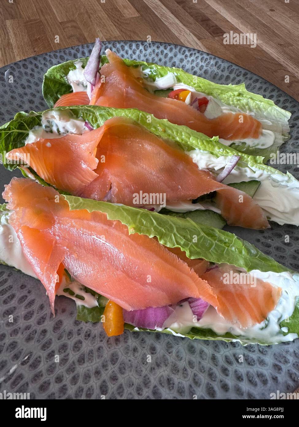 Räucherlachssalat Boote mit Frischkäse, Tomaten, rote Zwiebeln, Gurke Stockfoto