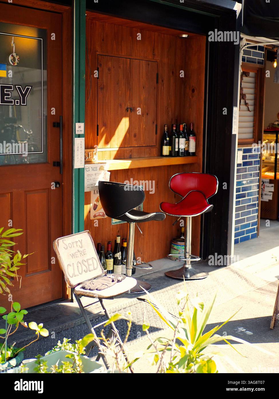 Rote und schwarze Stühle unter der Mittagssonne, Yanaka Ginza, Tokio Stockfoto