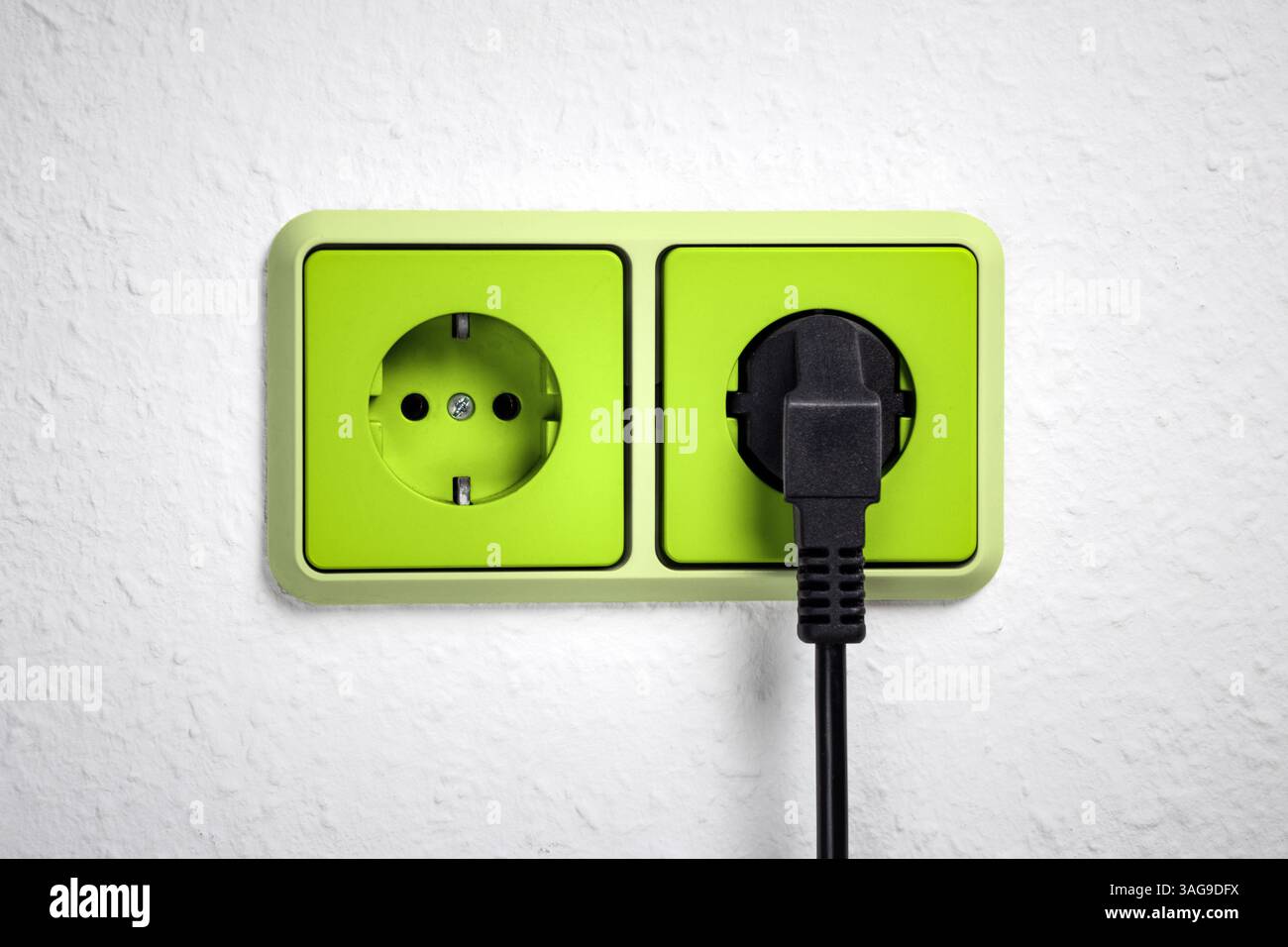 Grüne Steckdose mit Stecker an der Wand Stockfoto Grüne Steckdose mit Stecker an der Wand Stockfoto