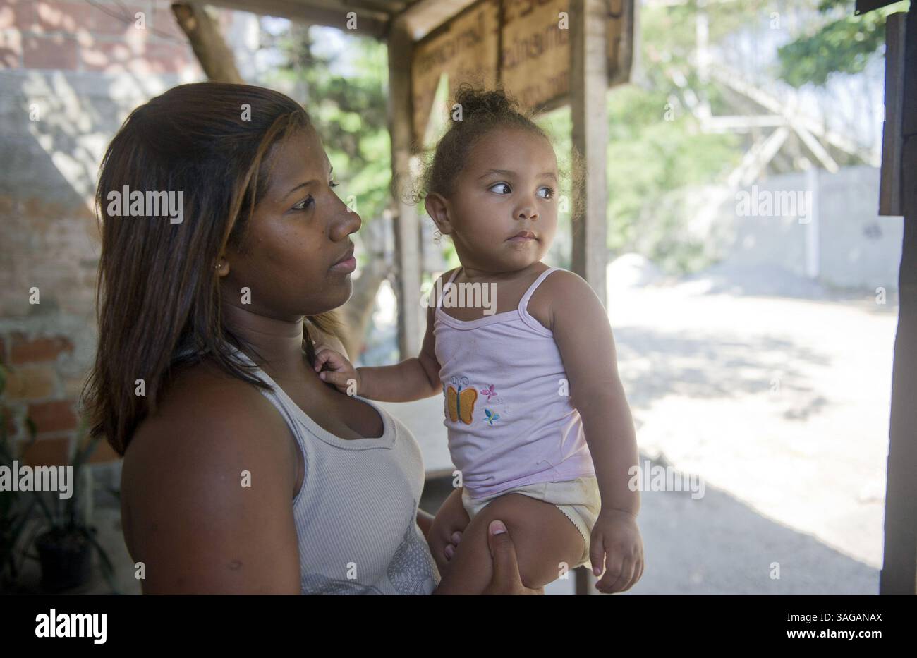 9. März 2012: Rio de Janeiro, BRA – Wanessa Christine Quintiano, 17 Jahre alt, spielt mit ihrer Cousine Ana Clara, 20 Monate vor ihrem Haus in Vila Autodromo, Rio de Janeiro, Brasilien. Quintiano ist so alt, dass er nur in die Arbeitswelt einsteigt. Quintiano sagte auch, dass alle ihre Familie und Freunde in der Favela leben. Wenn sie gezwungen wird, sich zu bewegen, wird sie von allem weggenommen, was sie weiß. Quintiano und ihr Cousin gehören zu den Tausenden von Einwohnern von Vila Autodromo und anderen Stadtvierteln wie es in dieser weitläufigen Stadt, die gebeten werden, ihre Häuser zu opfern, um olympischen fac unterzubringen Stockfoto