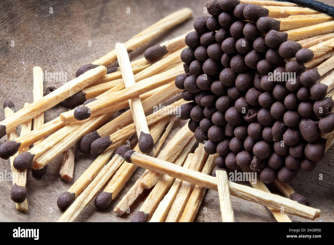 Verstreute Holzhölzer mit braunen Spitzen. Makroansicht von dicht gepackten hölzernen Streichhölzern. Stockfoto