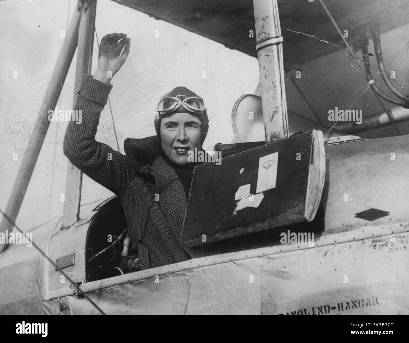 OP Mrs. Victor Bruce winkte aus dem Cockpit des Flugzeugs, als sie letztes Jahr die letzte Runde ihres Weltfluges absolvierte. Einen Monat im Himmel, ohne zu kommen, enthüllt Mrs. Bruce ihre Pläne. Ein erstaunlicher Versuch, einen Monat lang in einem kleinen Flugzeug zu leben, das über England fliegt, aber nie runterkommt, wird diesen Sommer von Honor Victor Bruce und seiner ebenso gewagten Frau unternommen. Sie müssen sich abwechseln beim Piloten, Kochen und Schlafen, während Treibstoff- und Lebensmittelvorräte ein- oder zweimal täglich von einem anderen Flugzeug über sie fliegen. März 1932. (Foto von Keystone). Stockfoto