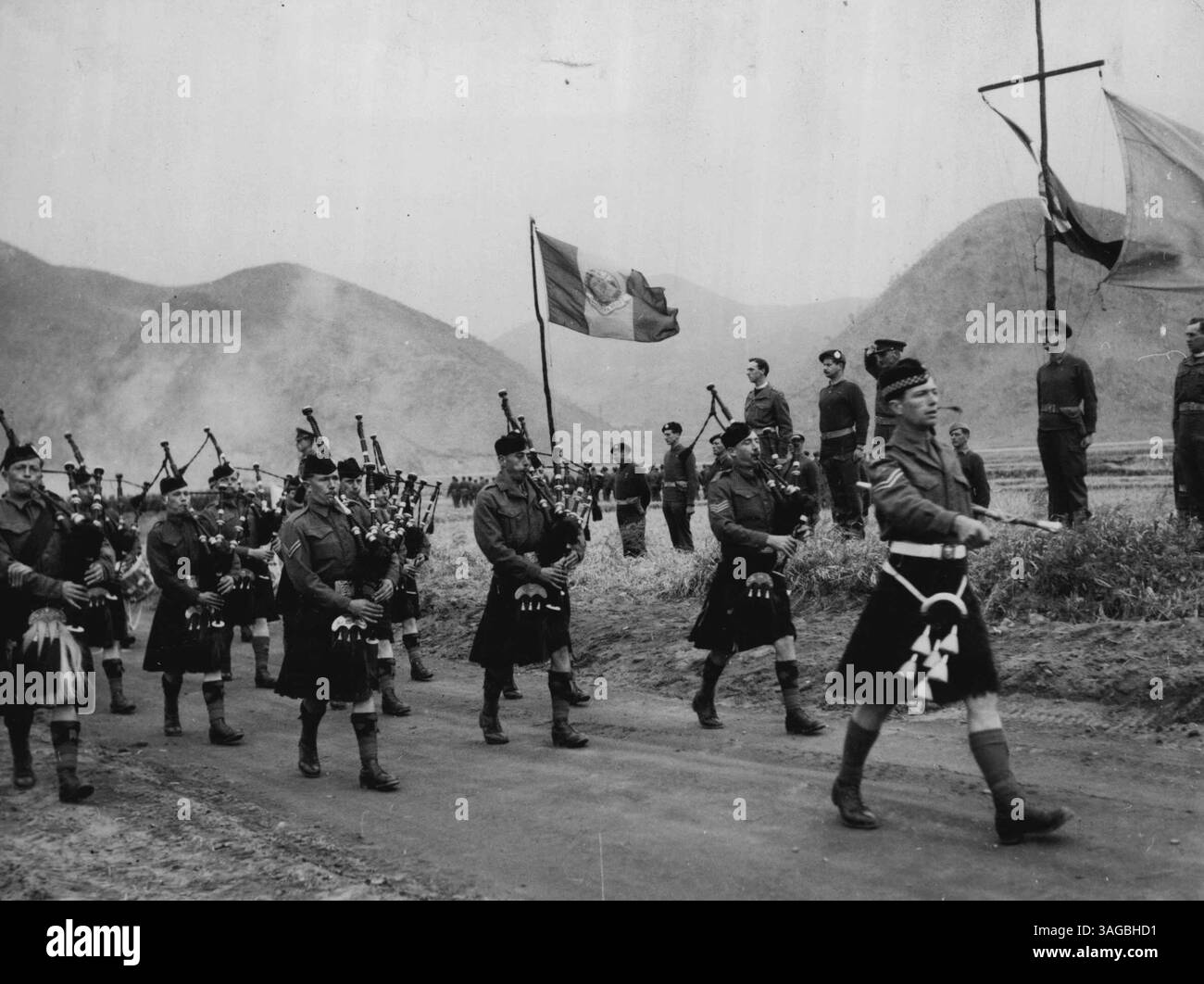 Kommandant der 27. Brigade in Korea, Brig. Basil Coad feiert den Gruß eines marsches von Mitgliedern der Brigaden irgendwo in Korea. Angeführt von den Pipern der Argyll ***** Sutherland Highlanders, der marsch Past folgte einer Gedenkfeier für Männer der Brigade, die in Korea getötet wurden. Vor dem marsch-Pat würdigte und gratulierte der Brigadeoffizier 16 der Brigadeoffiziere und Männer, die britische und amerikanische Auszeichnungen für ihre Rolle in den koreanischen Kämpfen erhielten. April 1951. (Foto von der Sektion Öffentlichkeitsarbeit, HQ BCOF, Japan). Stockfoto