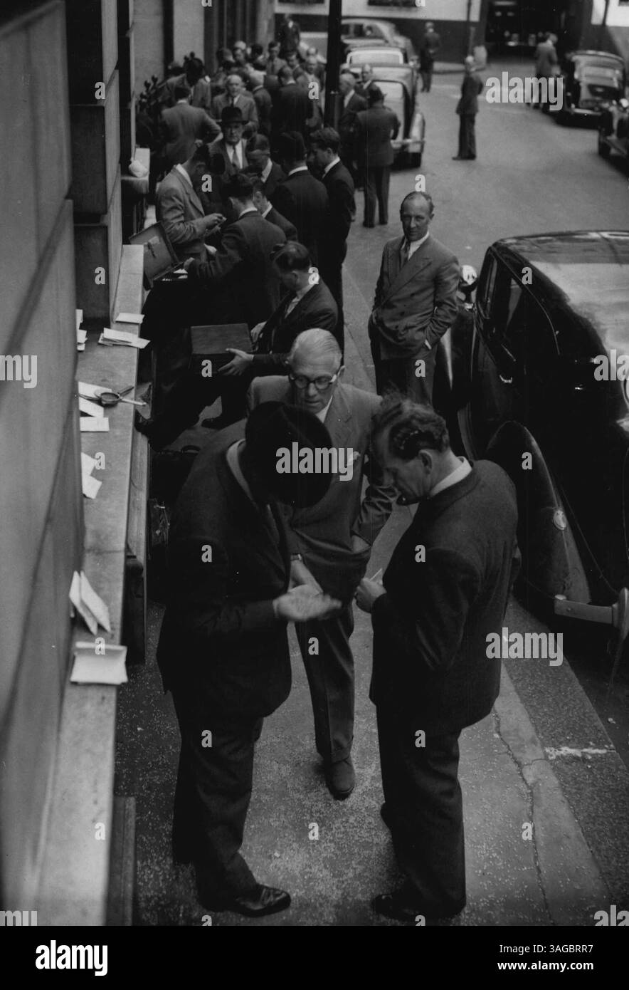 In der „Corn“ Street läuft es lebhaft - Held und dort hält ein Mann die Hand. Andere halten inne und sehen, was er hält. Der Ort ist eine Straße außerhalb des Londoner Maismarktes, wo sich Käufer und Verkäufer für die Transaktion von Geschäften treffen. Nach fast 14 Jahren ist wieder ein freier Getreidemarkt entstanden, alle staatlichen Beschränkungen wurden aufgehoben. Die Ware wird auf der Straße gezeigt, um potenziellen Käufern die Möglichkeit zu geben, Farbe und Menge besser zu beurteilen, als sie es bei Tageslicht können. 17. August 1953. Stockfoto